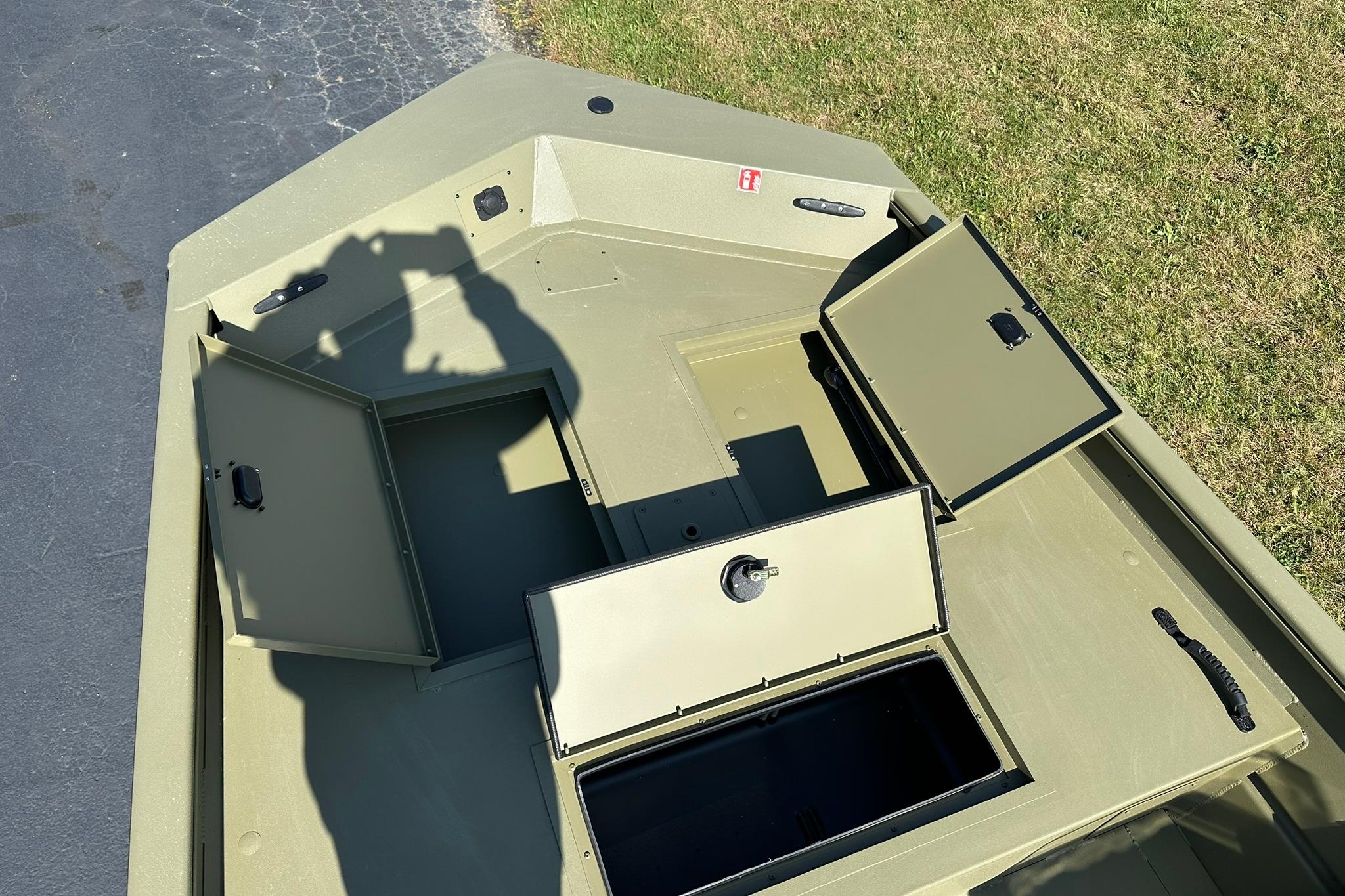 2026 Lowe Roughneck 1860SC boat with open storage compartments on a sunny day.