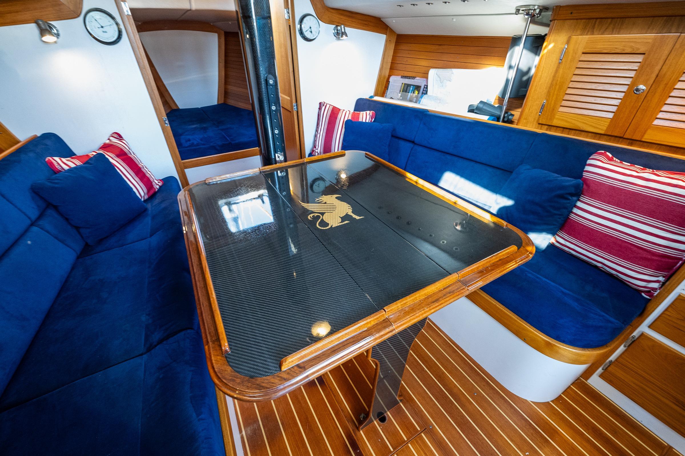 Interior of 2007 J Boats J/124 yacht with blue seating and elegant wooden finishes.