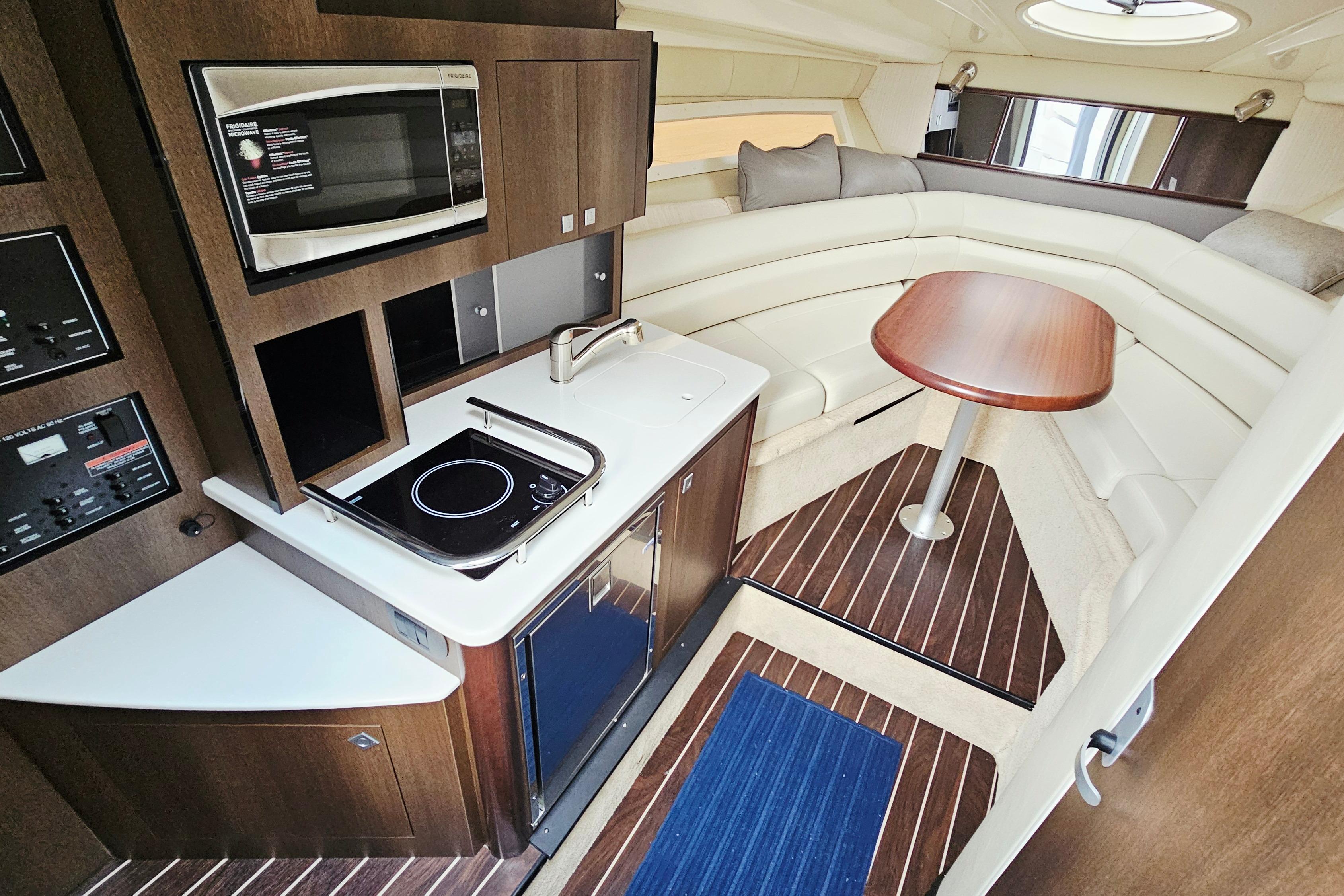 Luxurious interior of 2016 Monterey 295 Sport Yacht with kitchenette and seating area.