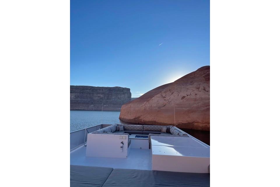 Luxury yacht "The Queen Elizabeth" by Adonia, 2021, cruising near scenic cliffs at sunset.