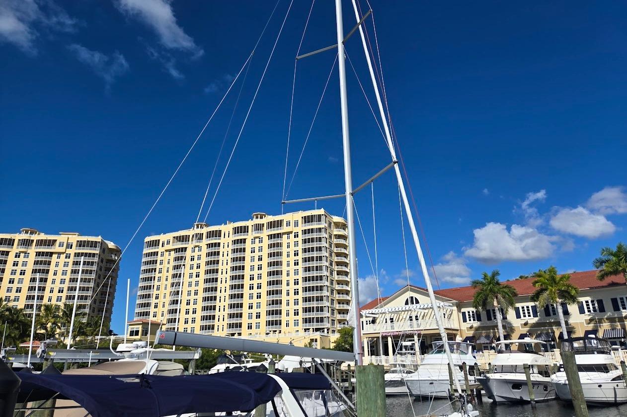 2023 Beneteau Oceanis 38.1 sailboat docked at marina with buildings in background.