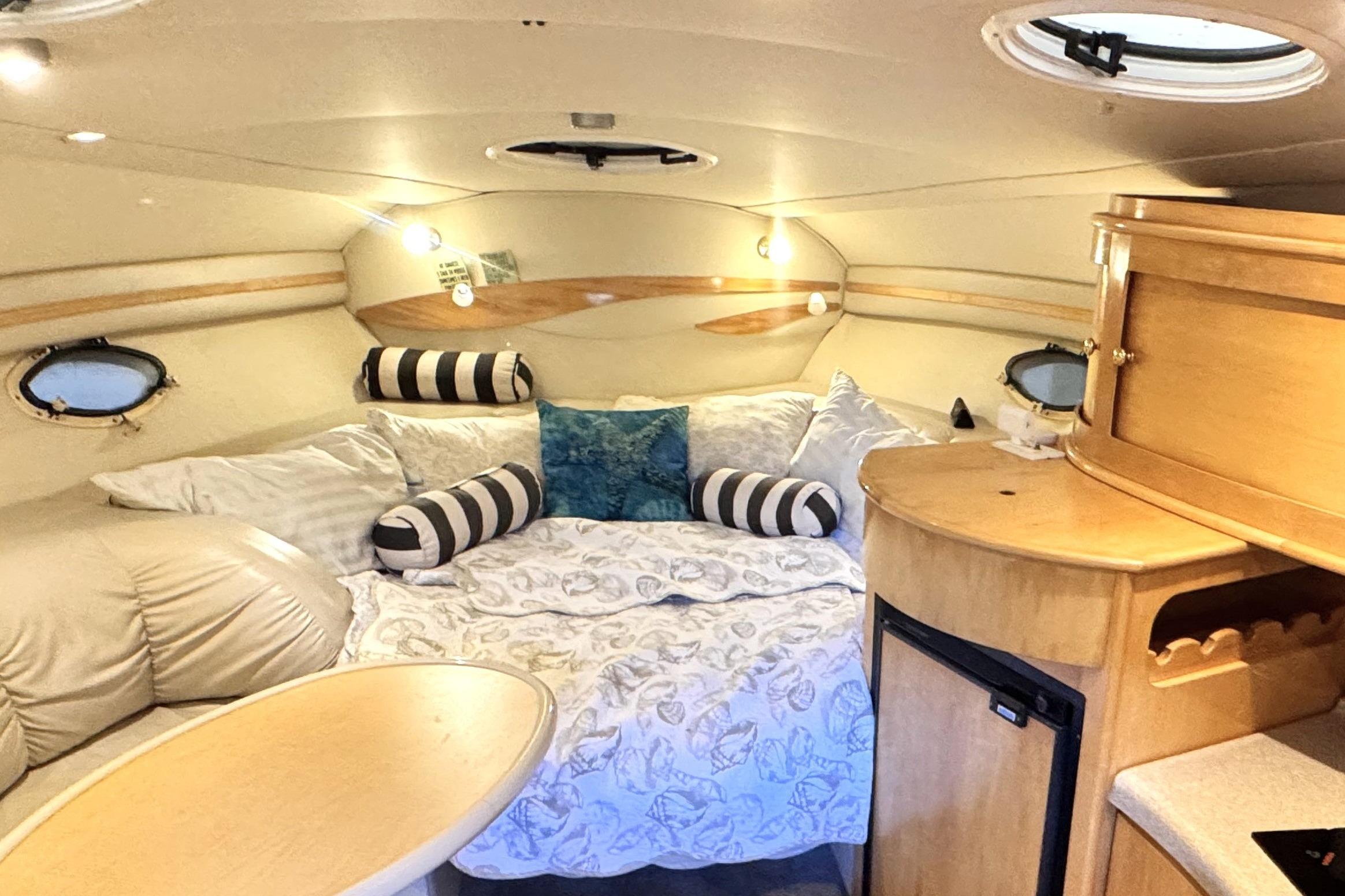 Cozy interior of 2002 Larson Cabrio 310 boat with comfortable seating and elegant wood finishes.