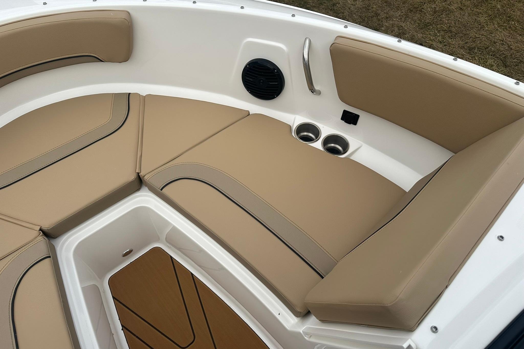 2026 Bayliner V20 boat interior with tan seating, cup holders, and speaker.