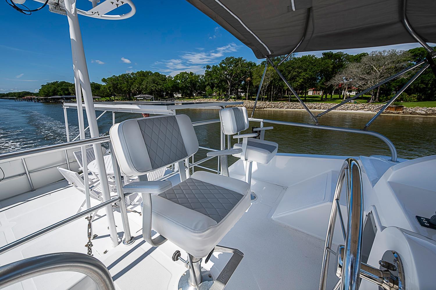 Flybridge of 2003 Magna Marine Nova Scotia 47 yacht with helm chairs and scenic water view.