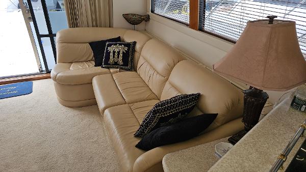 Luxurious interior of 2000 Carver 450 Voyager Pilothouse with beige leather sofa.