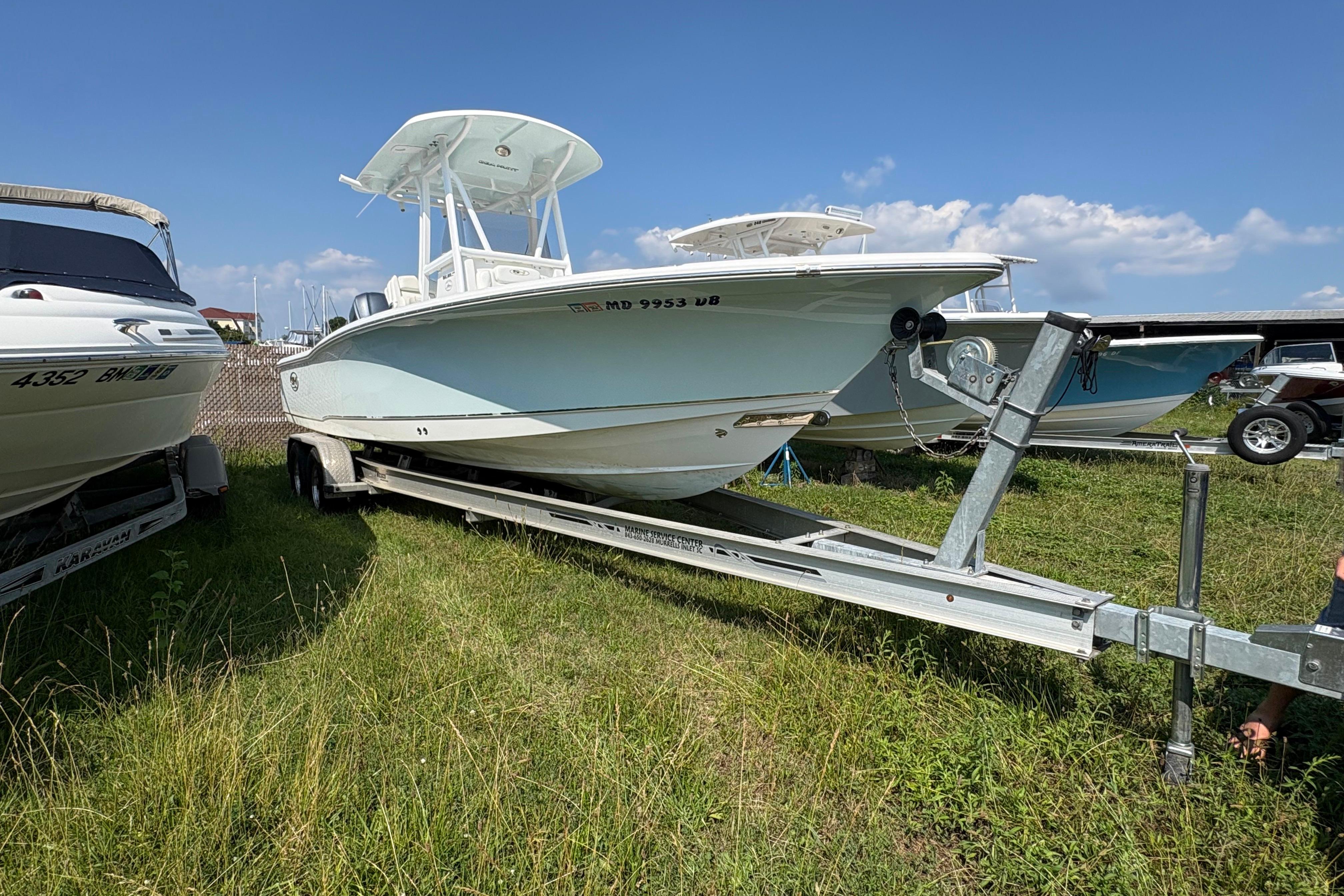 2017 Sea Hunt BX 25 BR boat on trailer, parked on grass under blue sky.