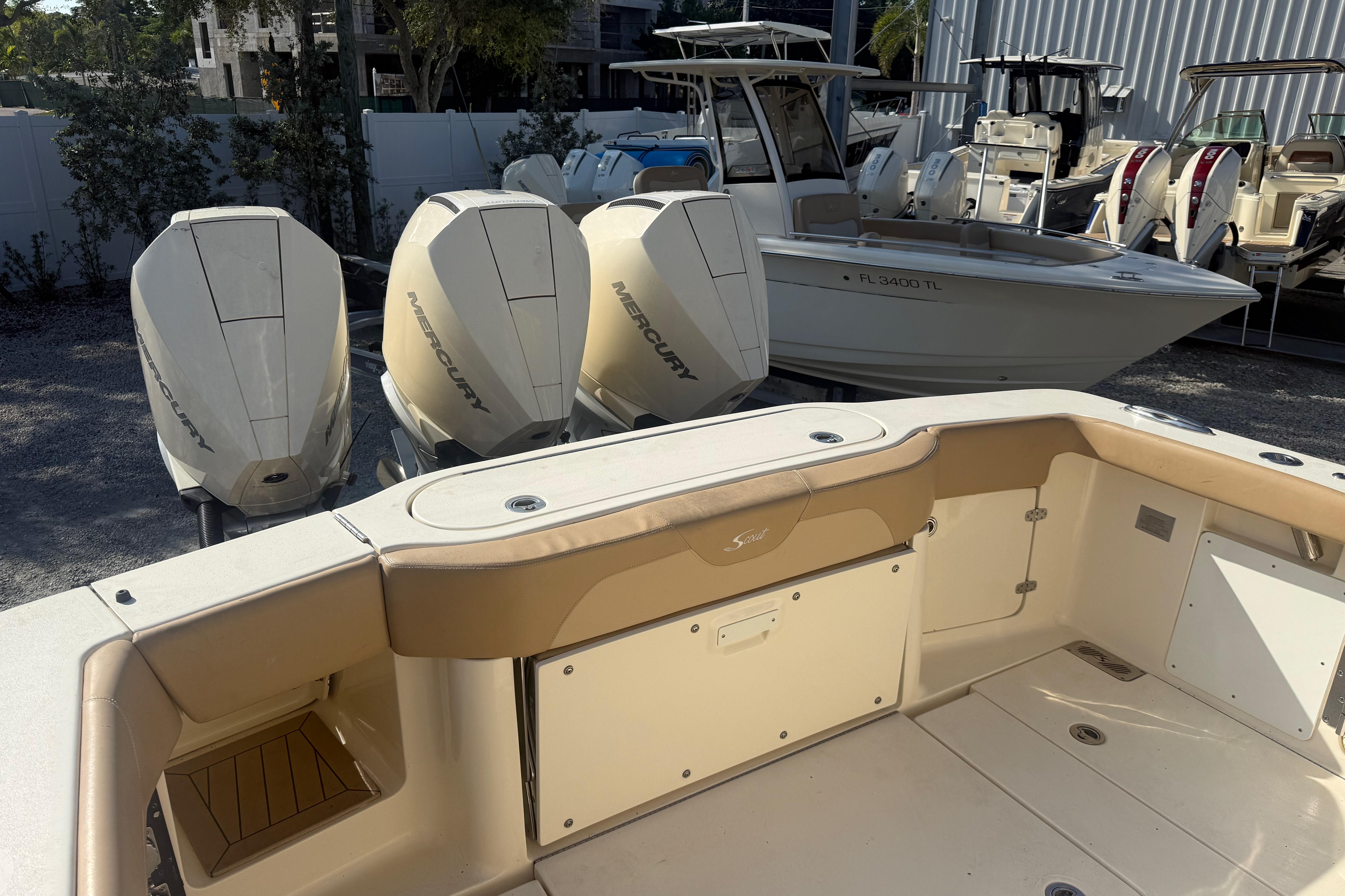 2022 Scout 355 LXF boat with Mercury engines, docked in a marina.