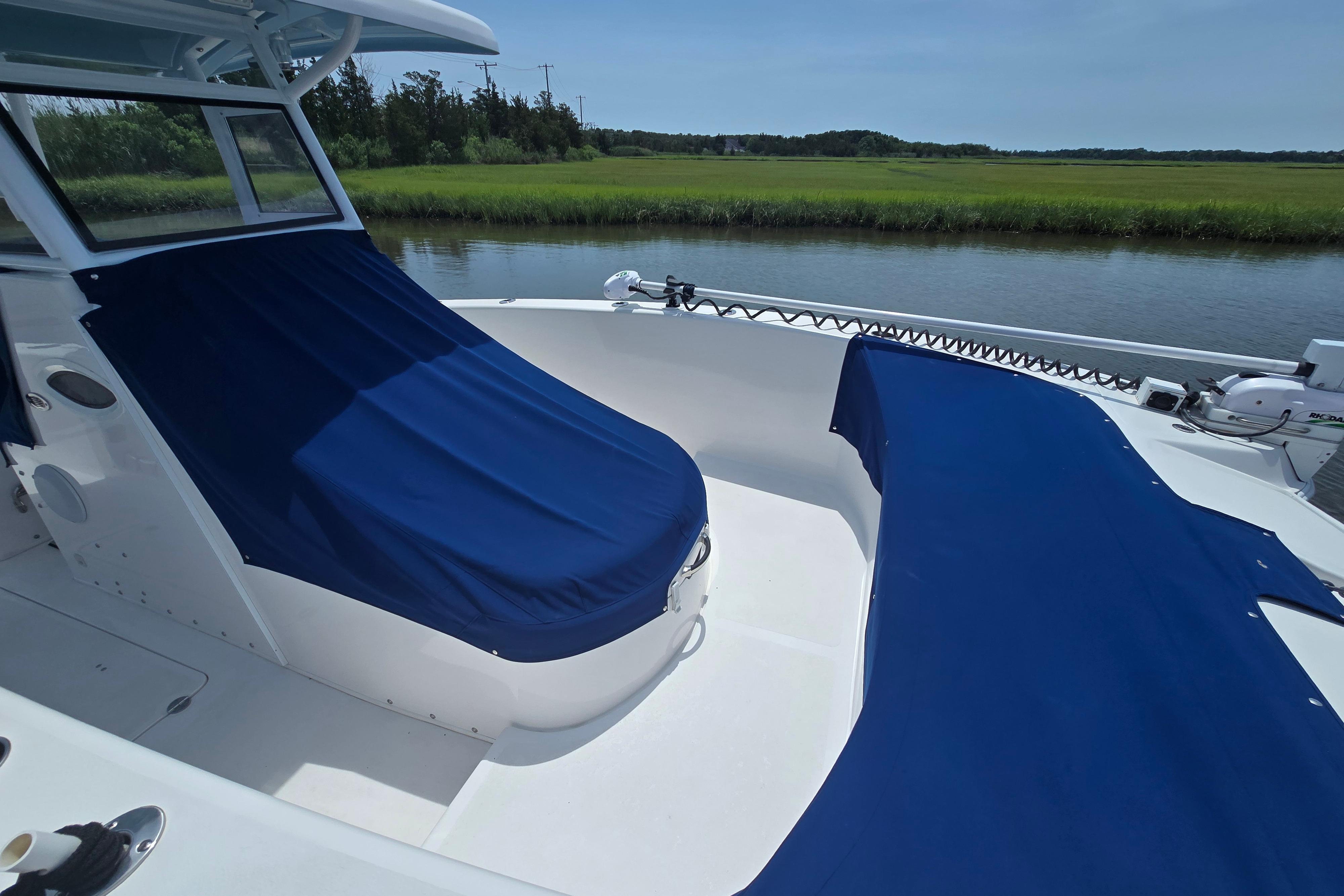 2021 Twin Vee 280 GFX CC boat with blue covers on a calm river.