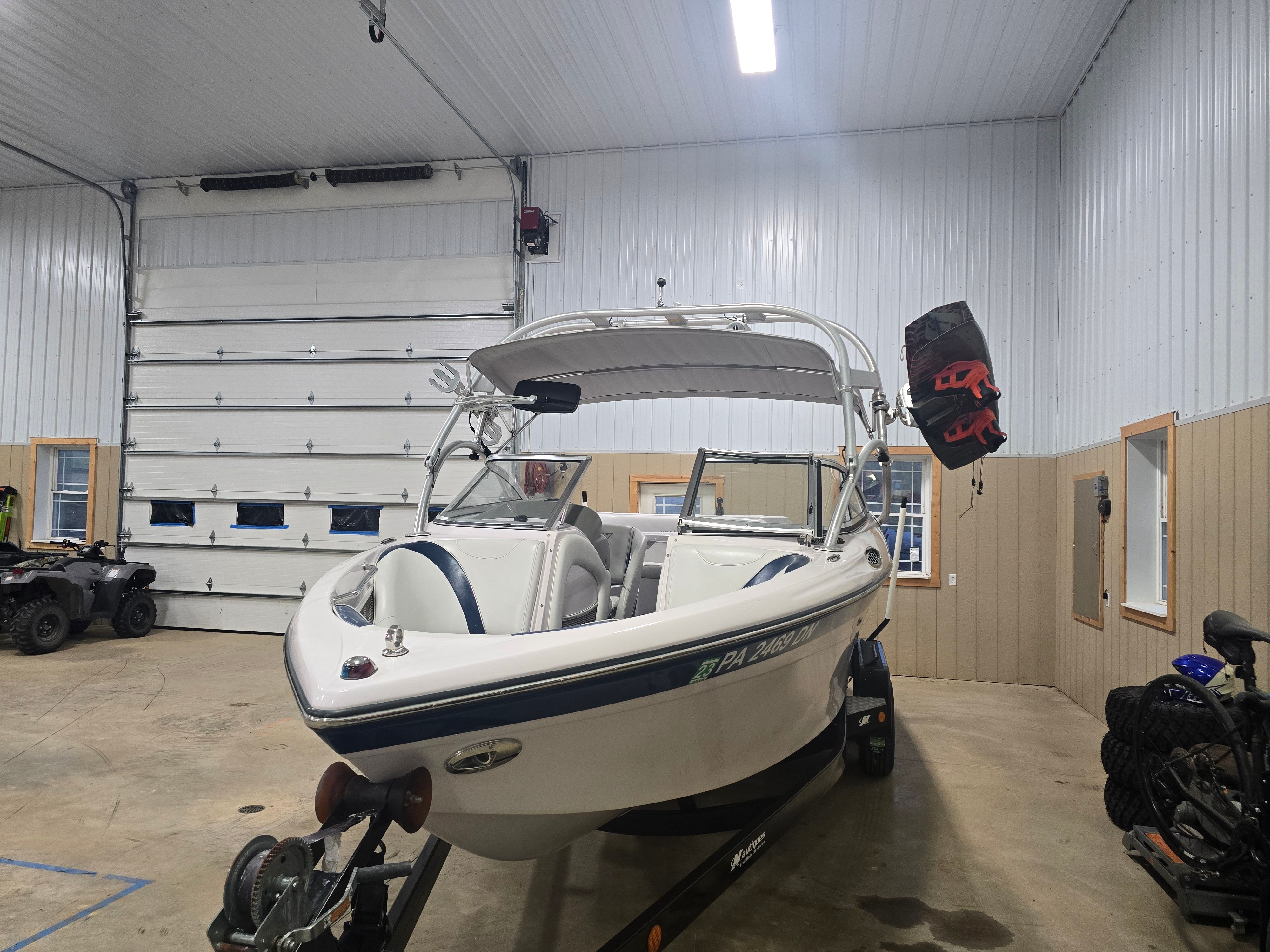 2006 Correct Craft 228 boat parked in a garage.