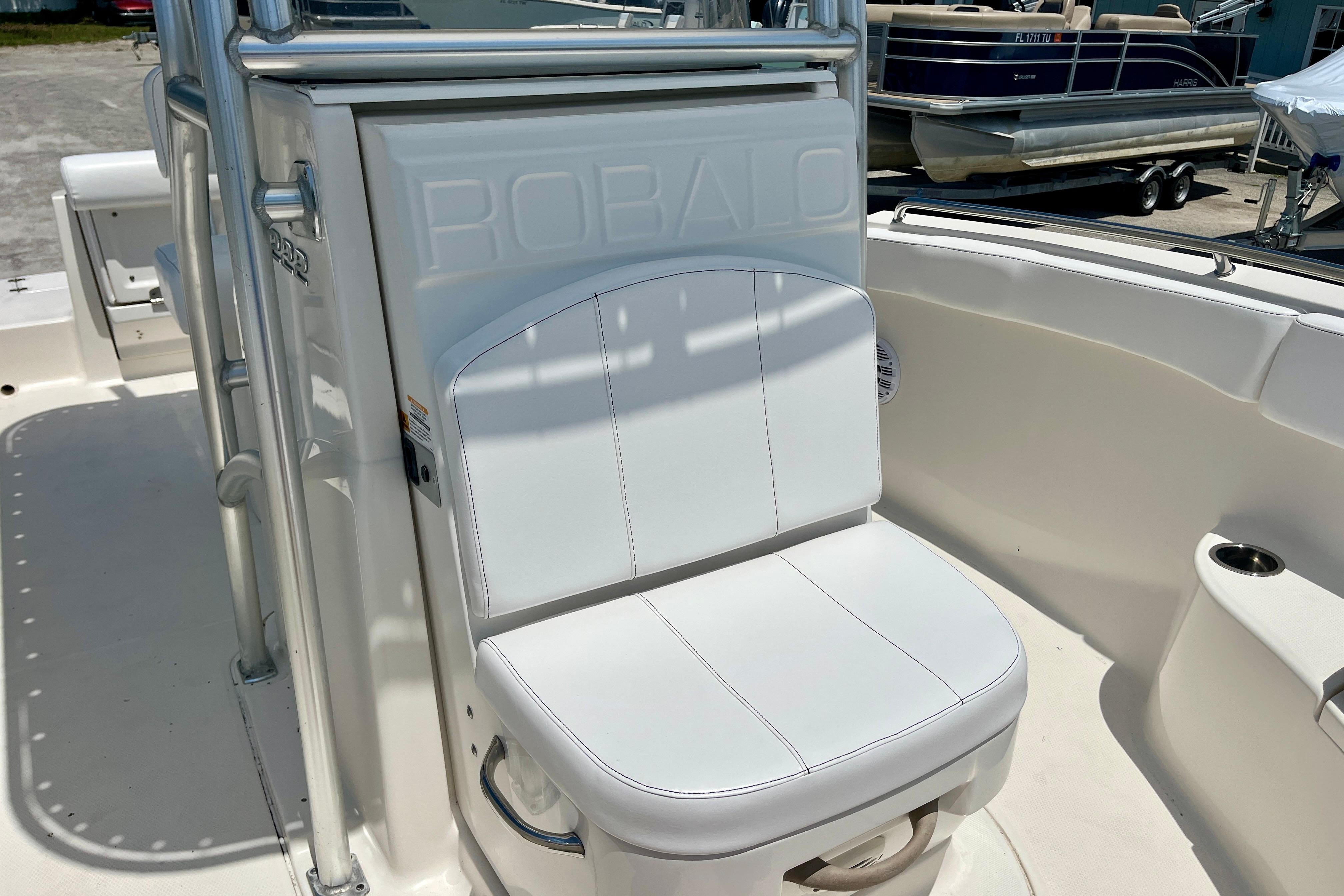 2016 Robalo R222 Center Console boat seat, white upholstery, docked near other boats.