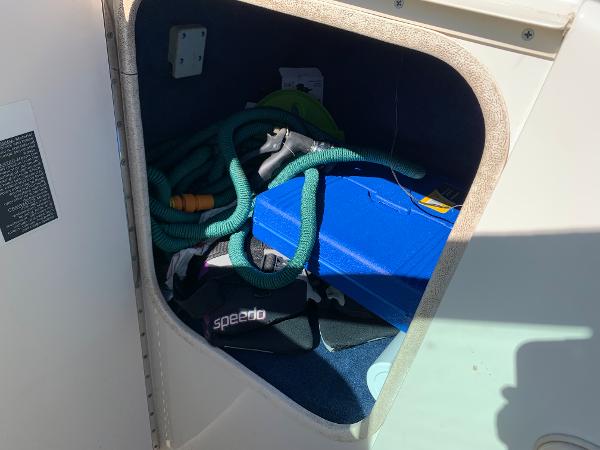 Storage compartment of a 2000 Sea Ray 210 Bow Rider with boating accessories.
