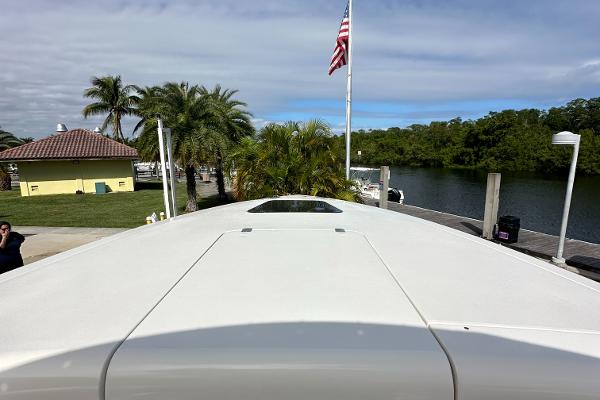 2005 Intrepid 323 boat docked near palm trees and waterway.
