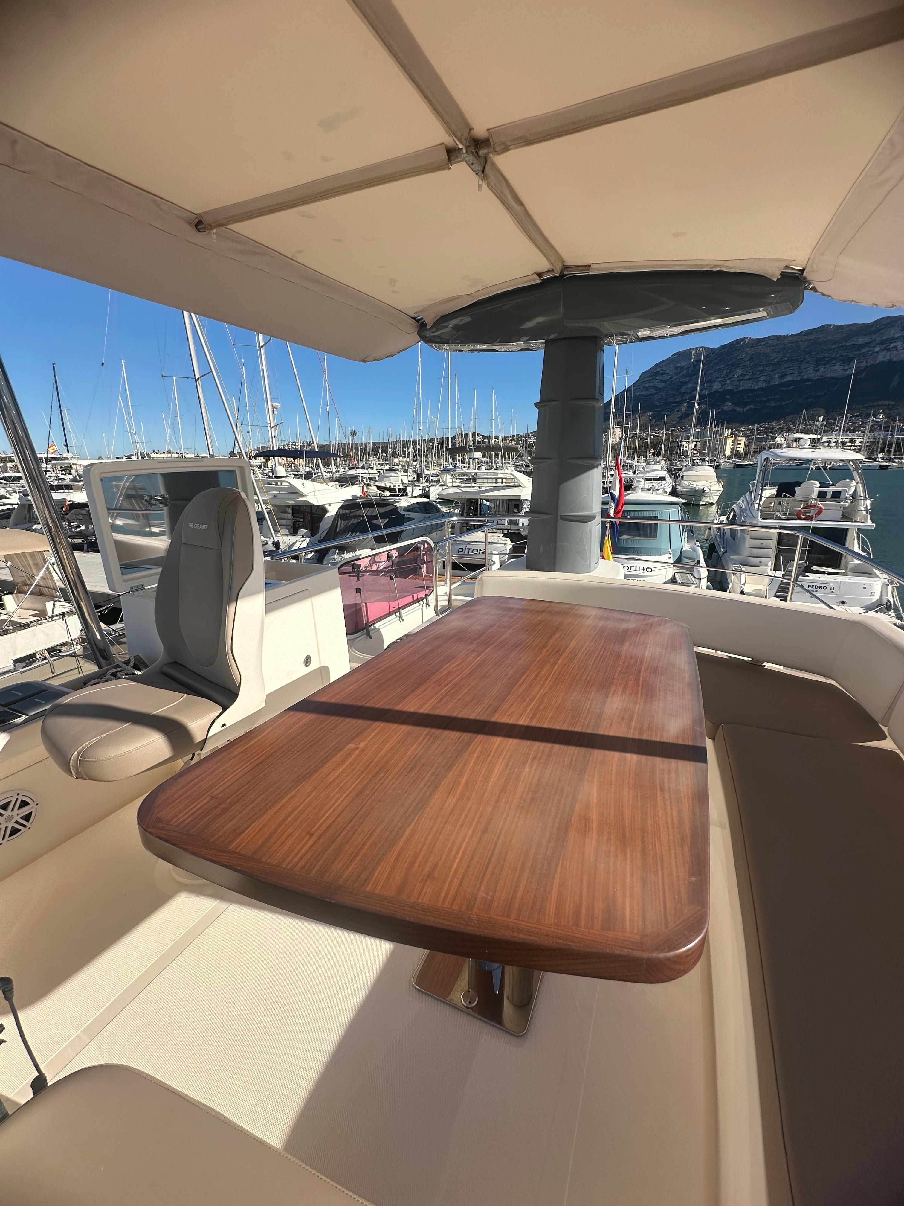2014 Azimut Magellano 50 yacht deck with wooden table, marina view.