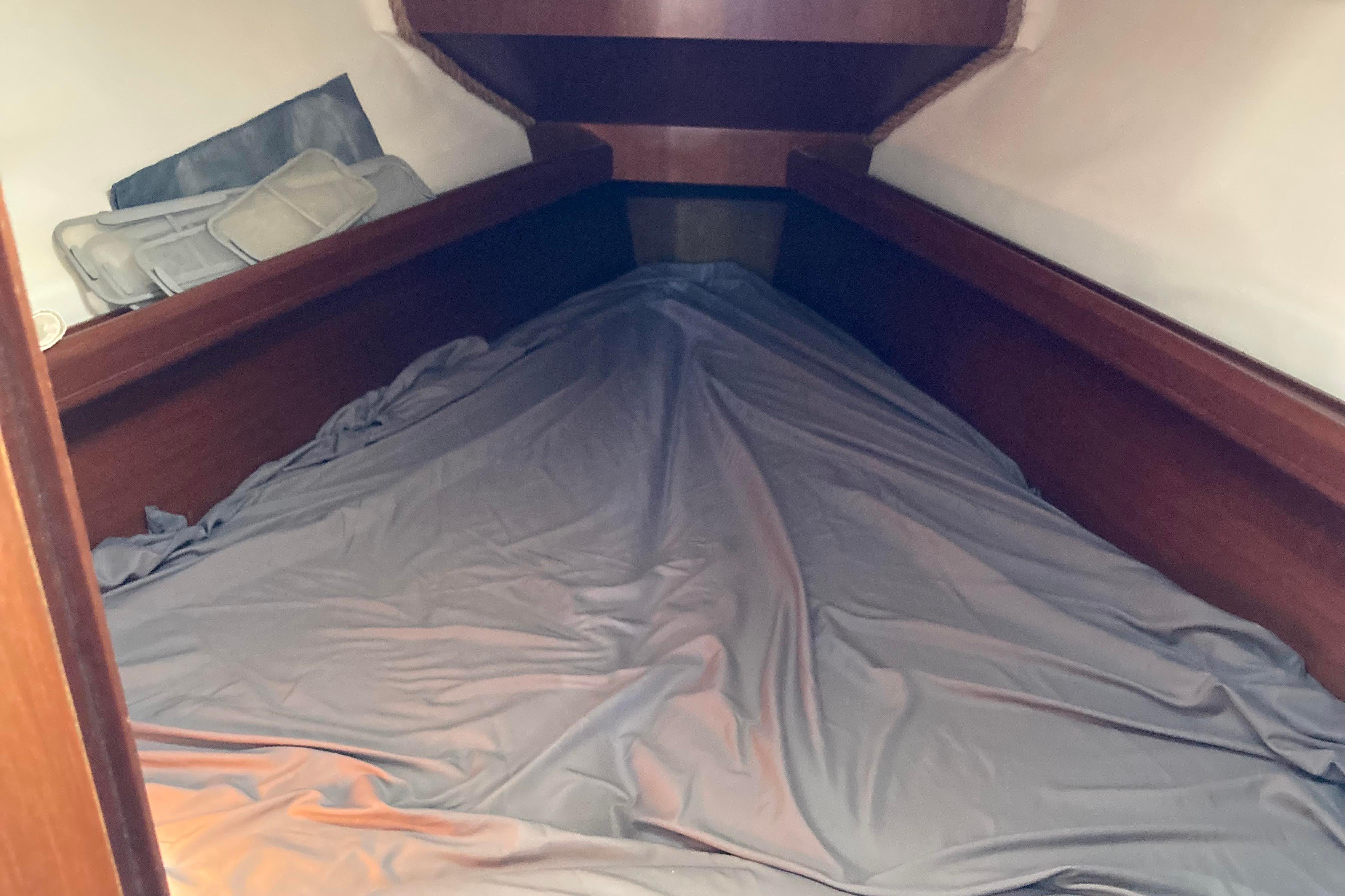 Cozy cabin interior of 2000 Beneteau Oceanis 311 sailboat with neatly made bed.