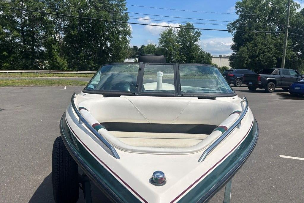 1999 Malibu Response boat in parking lot, front view with trees and cars in background.