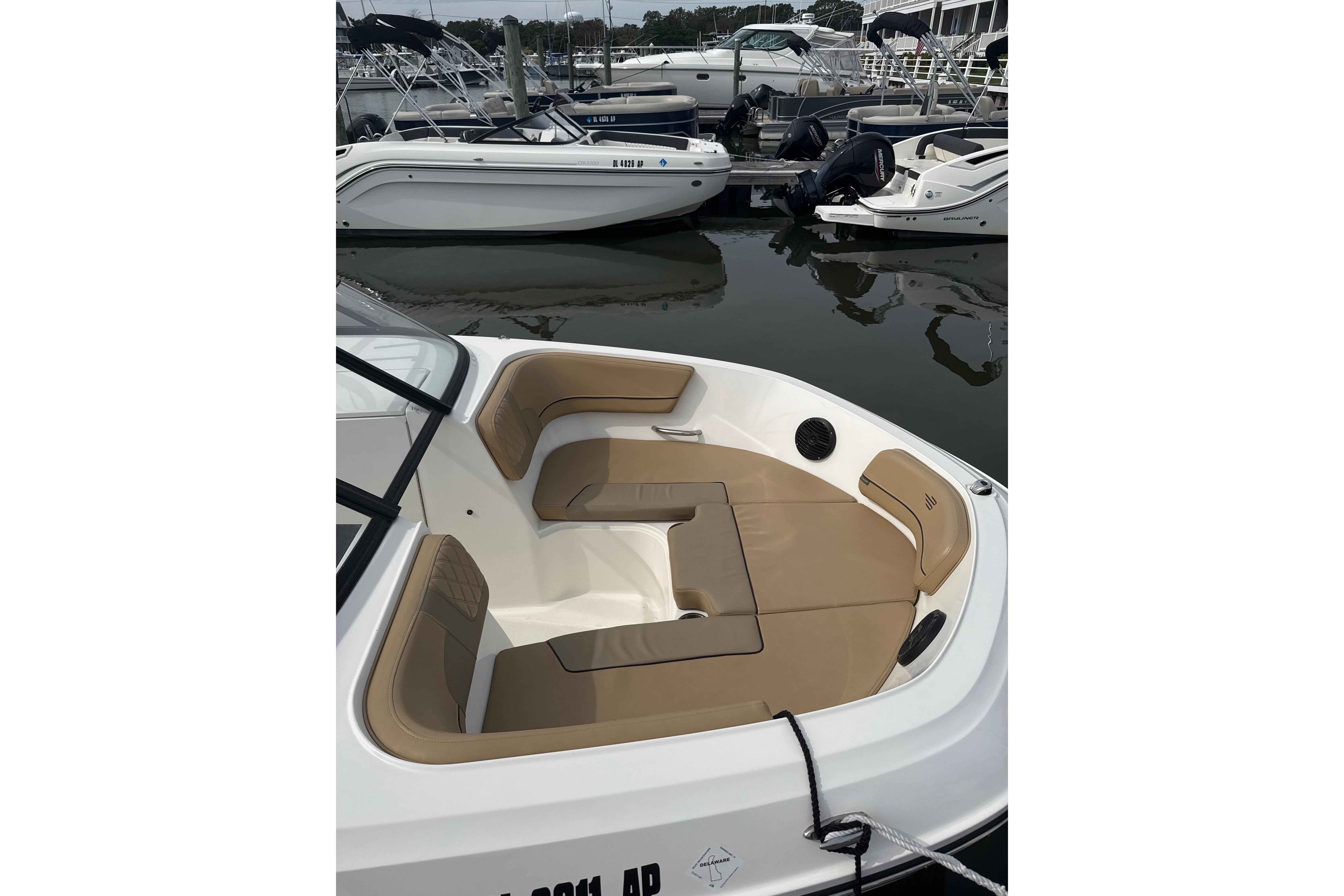 2025 Bayliner VR6 Bowrider OB with tan seating, docked in a marina.