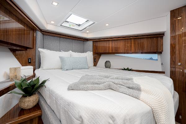 Luxurious bedroom interior of 2021 Riviera 5400 Sport Yacht with modern decor.