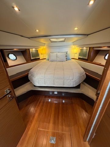 The 2017 Tiara Yachts C44 Coupe cabin features a cozy bed and wooden flooring.
