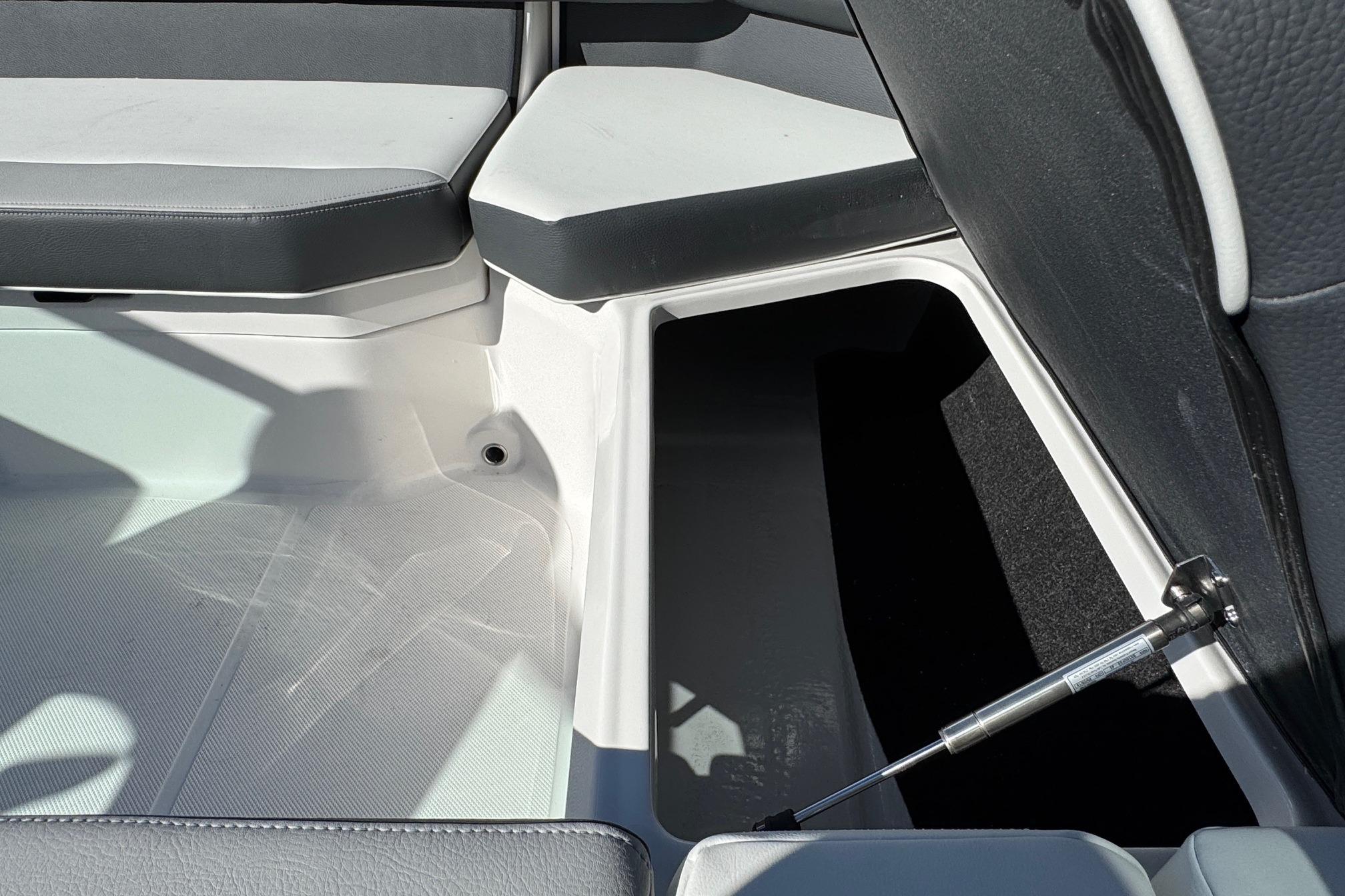 2026 Regal 21 OBX boat interior storage compartment with cushioned seating.