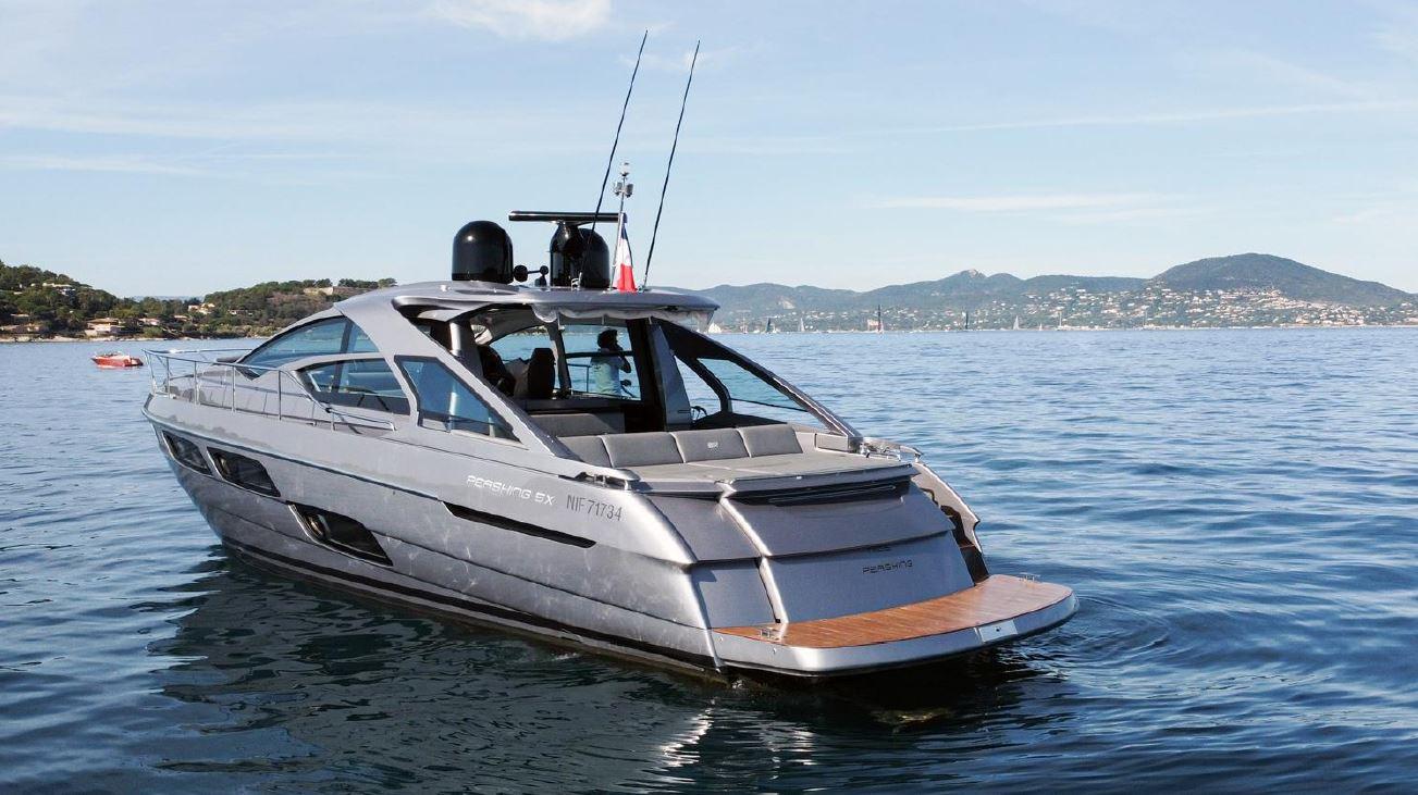 2018 Pershing 5x yacht cruising on calm waters with scenic background.