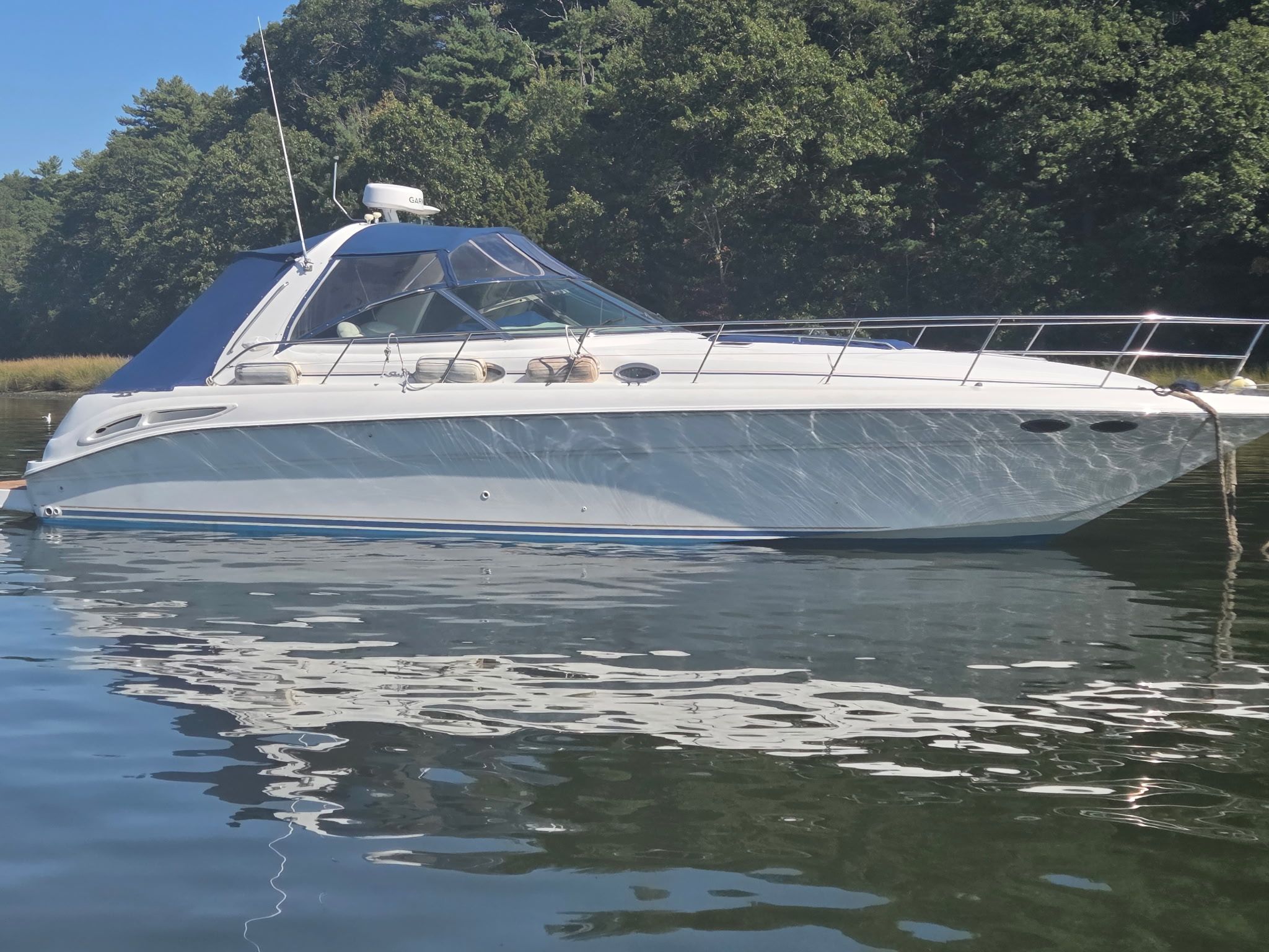 2000 Sea Ray 410 Sundancer on calm water with forest backdrop.
