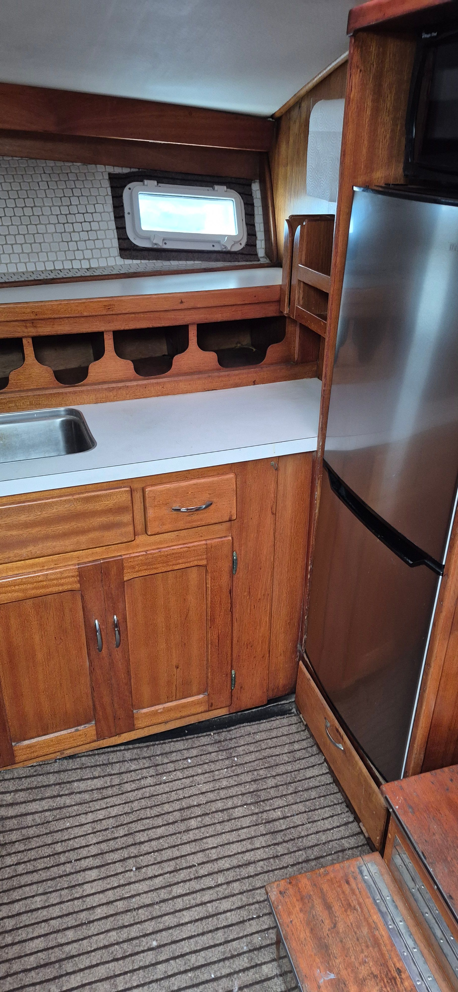 Interior of 1976 Egg Harbor 33 Sportfisher with wood cabinetry and stainless steel appliances.