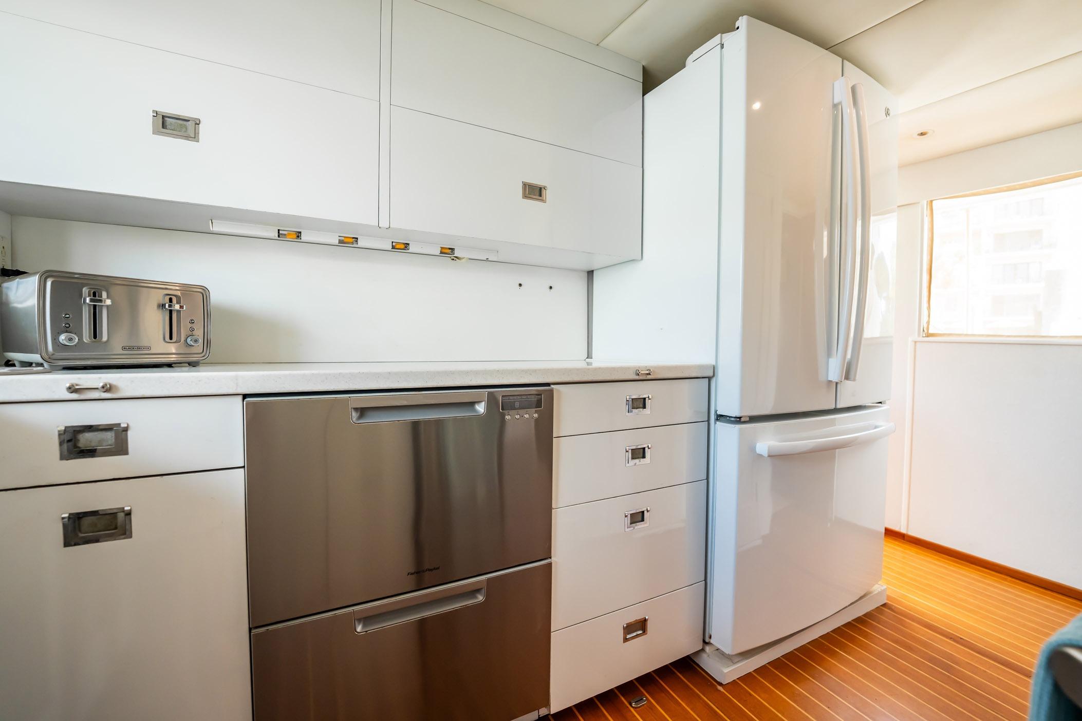 Modern kitchen in a 1972 Trumpy 72 Motor Yacht with sleek appliances and wooden flooring.