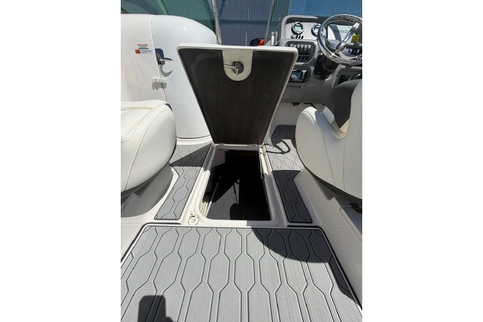 2024 Robalo R207 Dual Console boat interior with open storage compartment and modern dashboard.