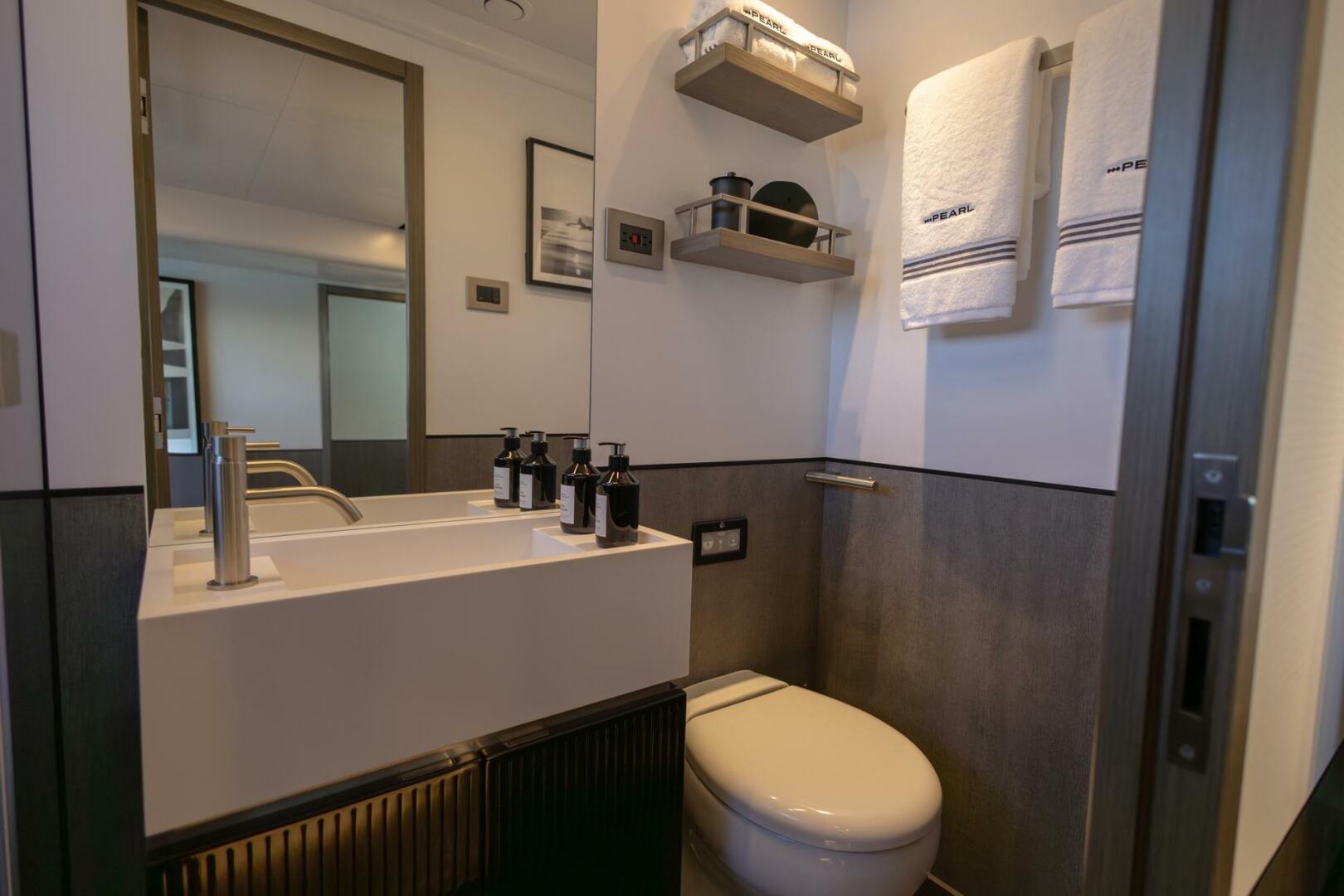 Modern bathroom in Pearl 72 yacht, featuring sleek sink, towels, and elegant decor, 2023 model.