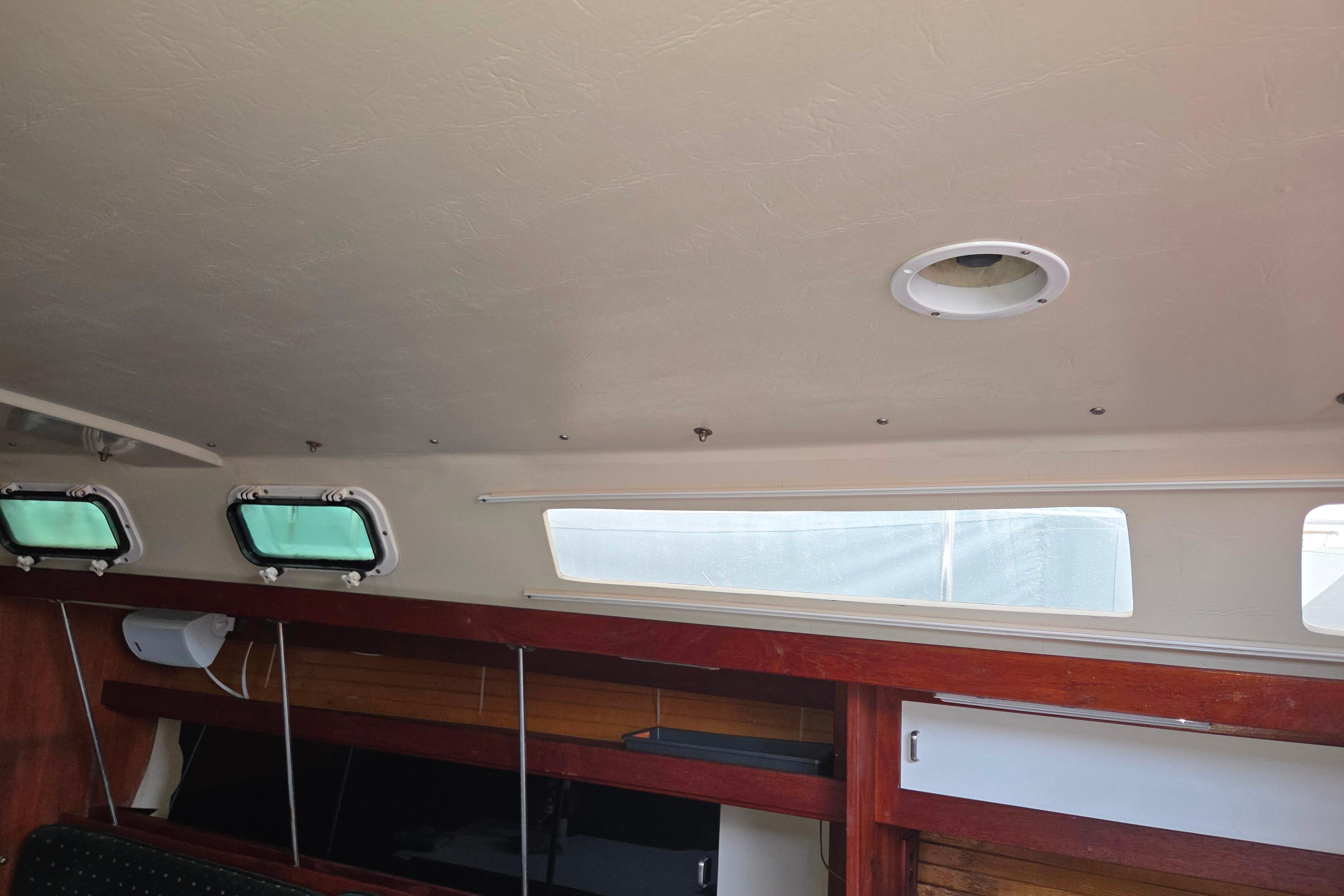 Interior cabin view of a 1986 Catalina 355 sailboat, featuring windows and wooden accents.
