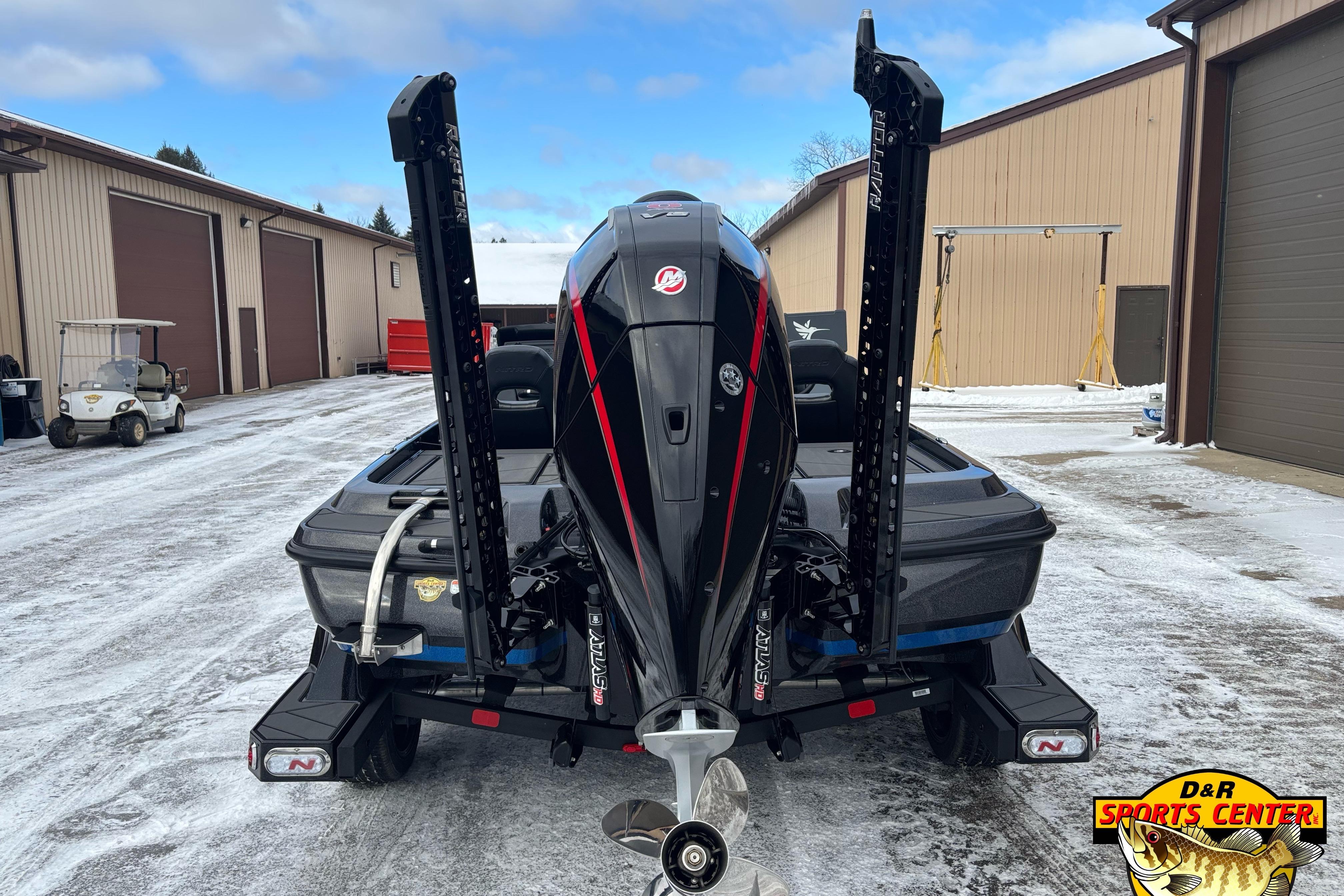 2026 Nitro Z21 XL boat with powerful engine, parked on snowy ground near storage buildings.