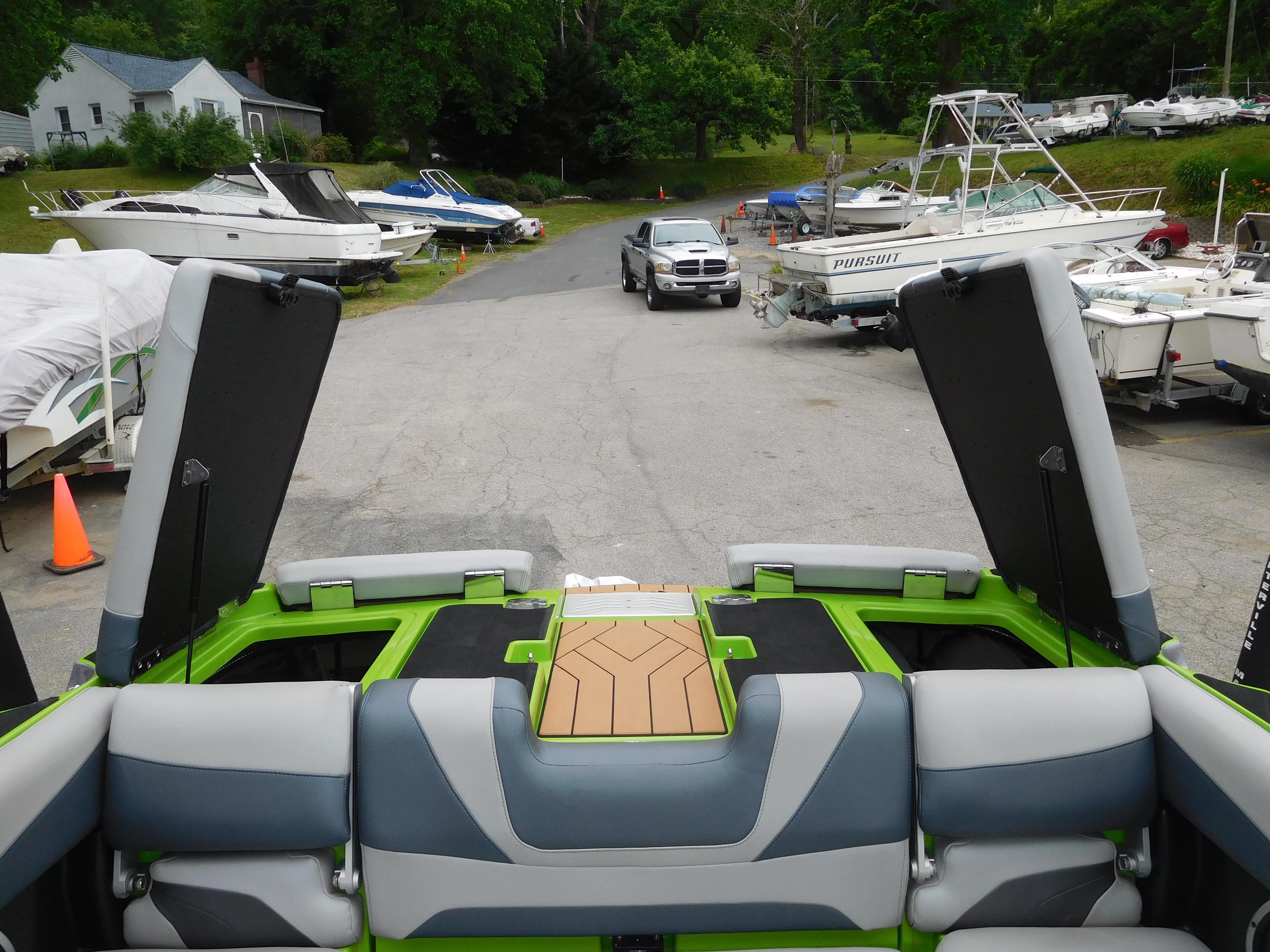 2017 Malibu Wakesetter 24 MXZ at a boatyard with open storage compartments.