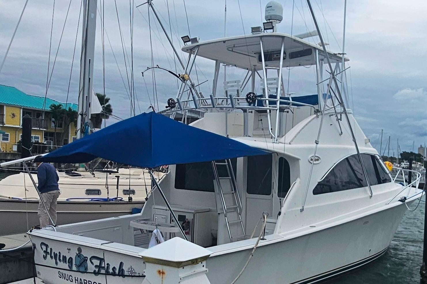 2000 Ocean Yachts 40 Super Sport docked, featuring a blue canopy and sleek design.