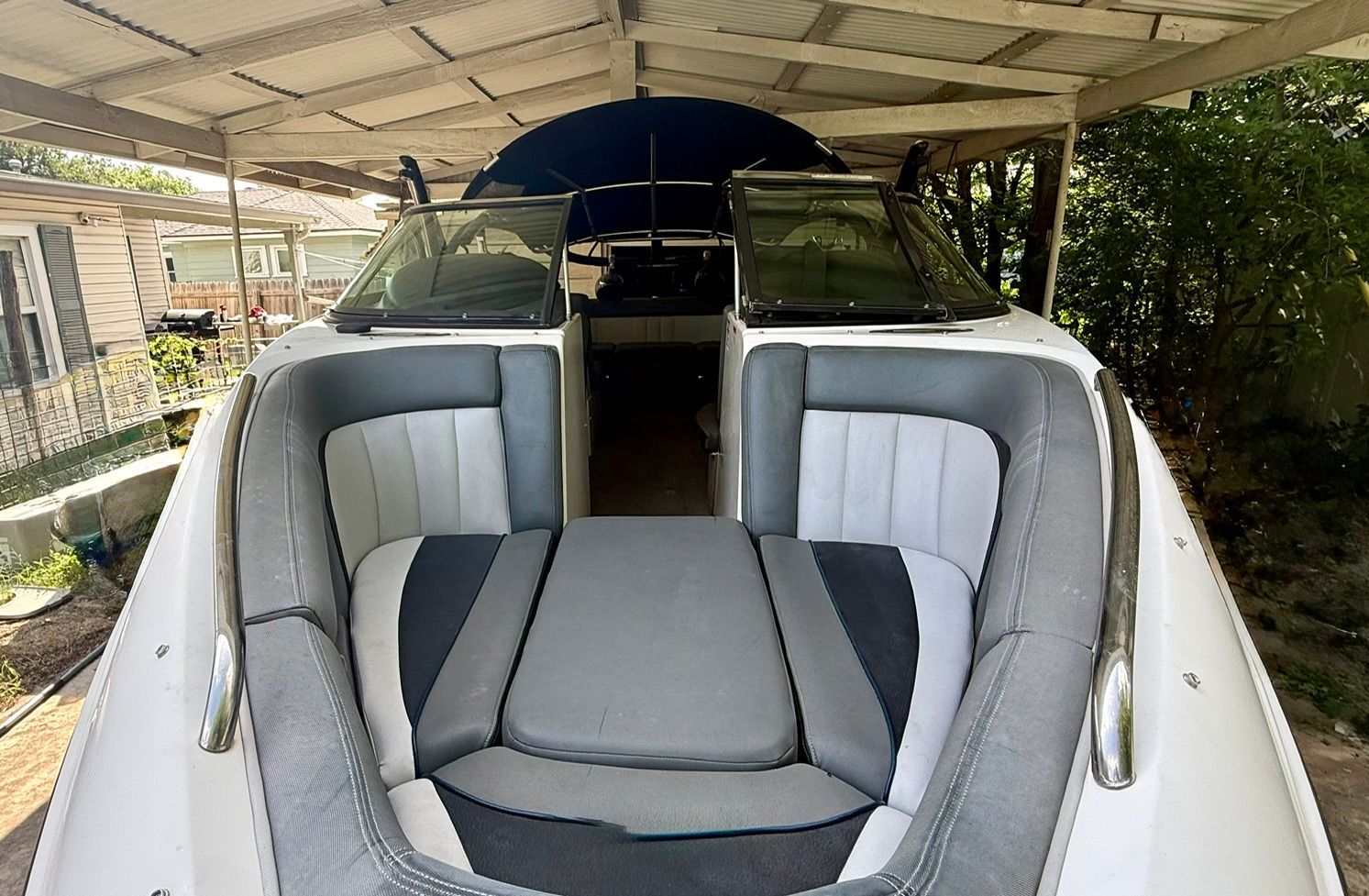 The image shows the stern of a 2012 Supra Launch 242 boat under a carport.