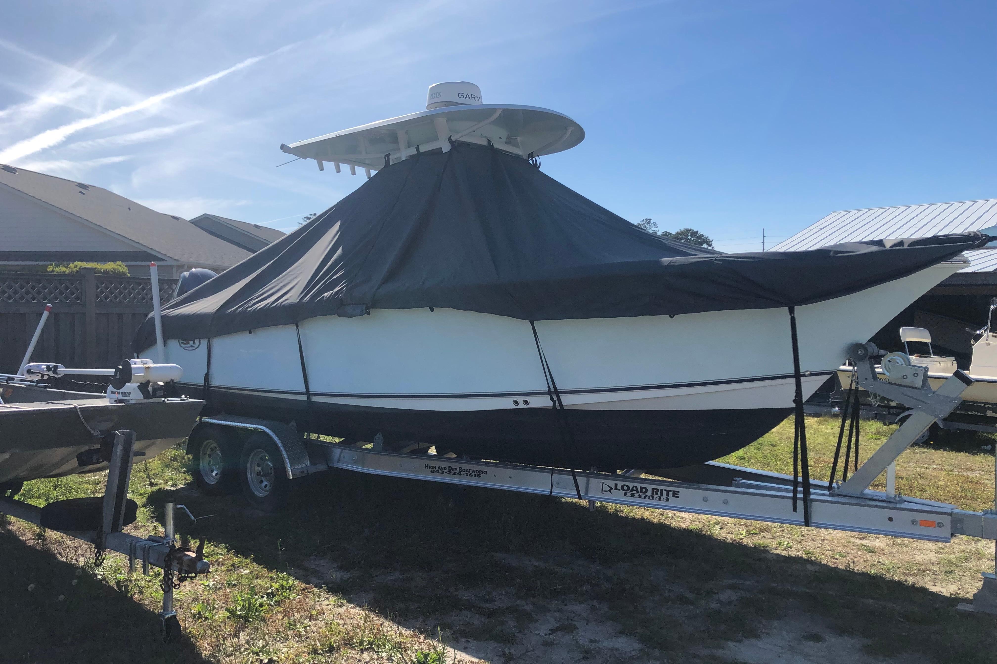 2015 Sea Hunt Gamefish 25 boat covered on trailer, parked outdoors.