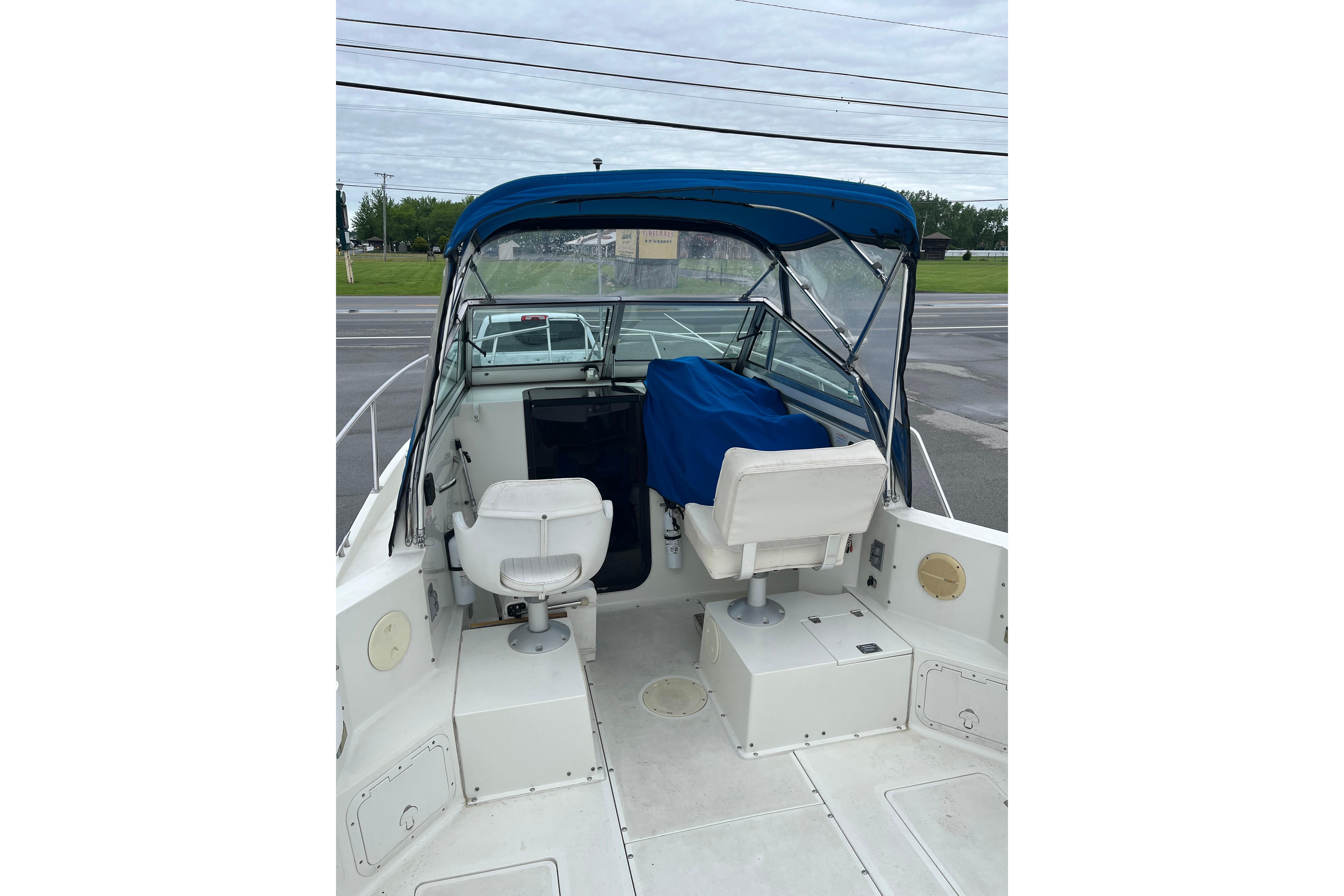 1995 Celebrity 2500 Fish Hawk boat interior with blue canopy and seating.