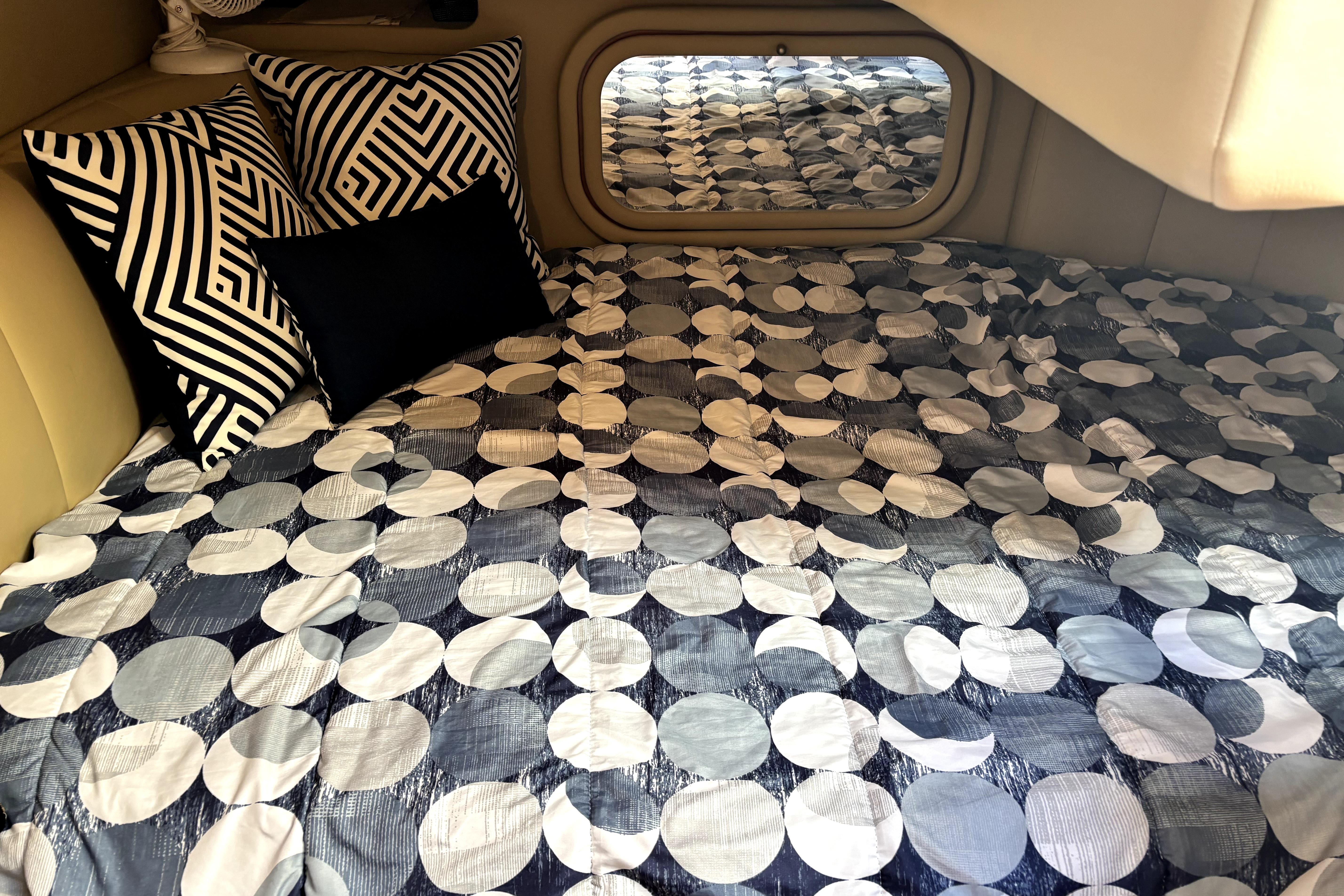 2006 Rinker Fiesta Vee 342 cabin with geometric pillows and patterned bedding.