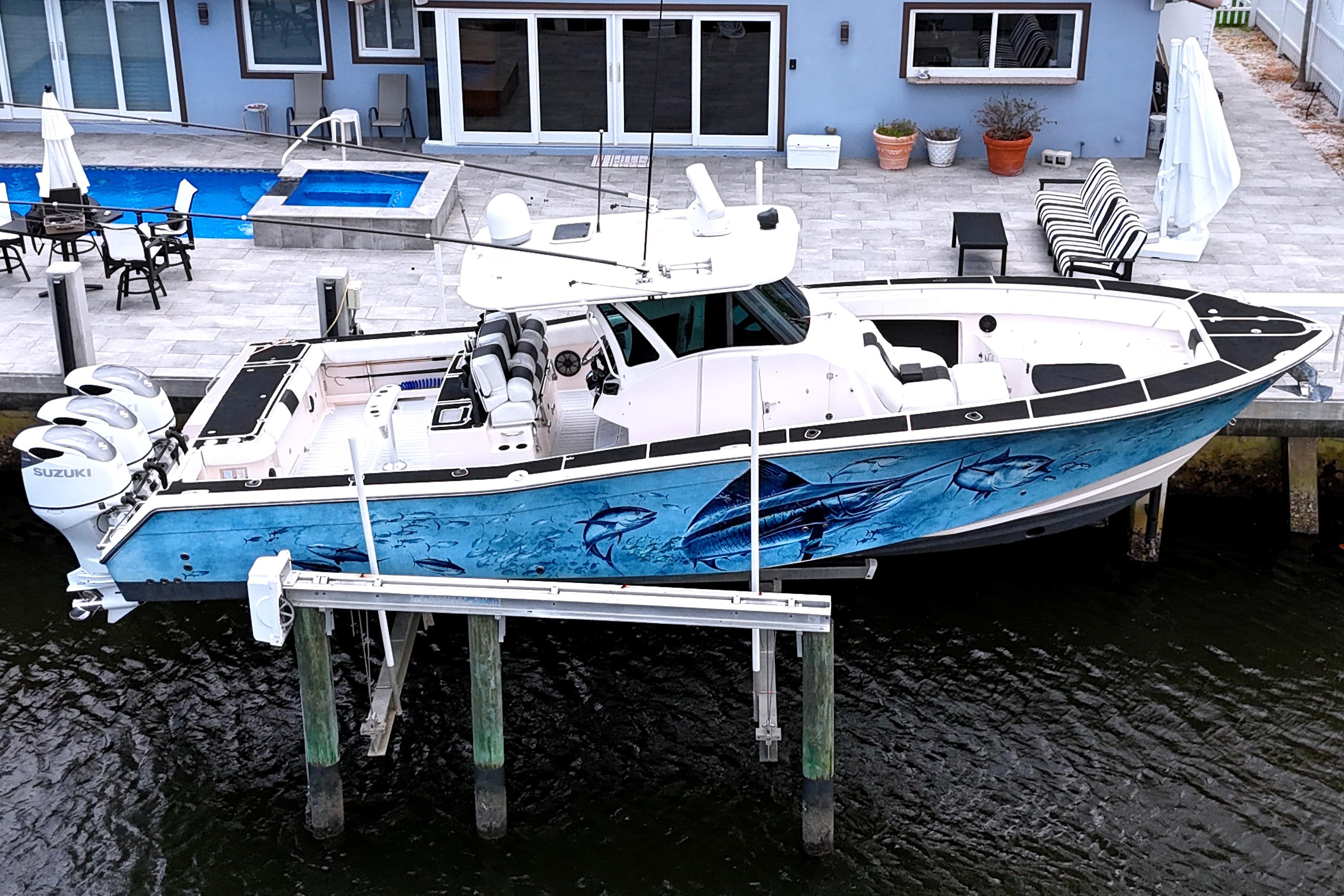 2010 Grady-White Canyon 366 boat docked, featuring vibrant marine artwork on hull.
