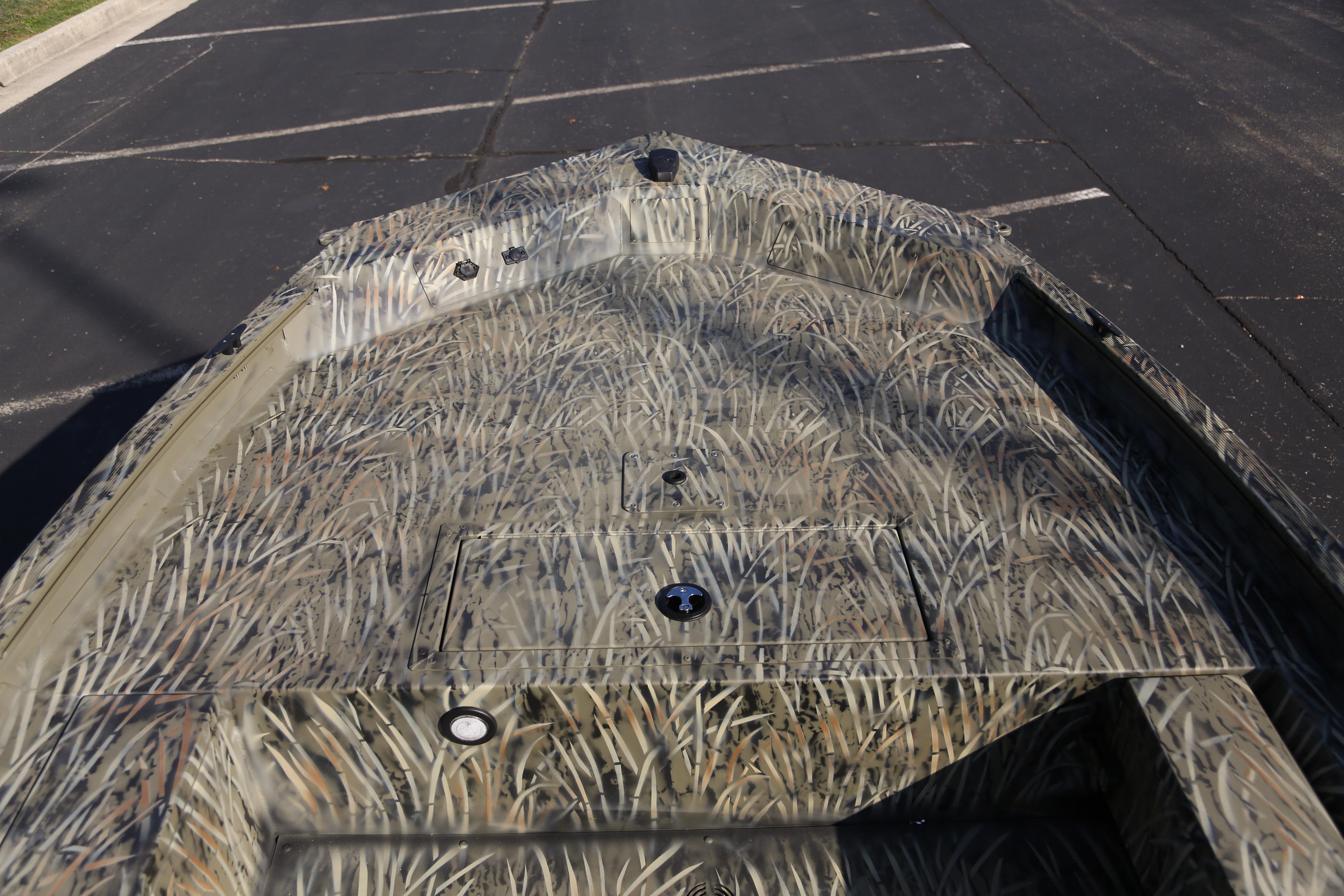 2026 Tracker Grizzly 1654 T Sportsman boat with camouflage design on a parking lot.