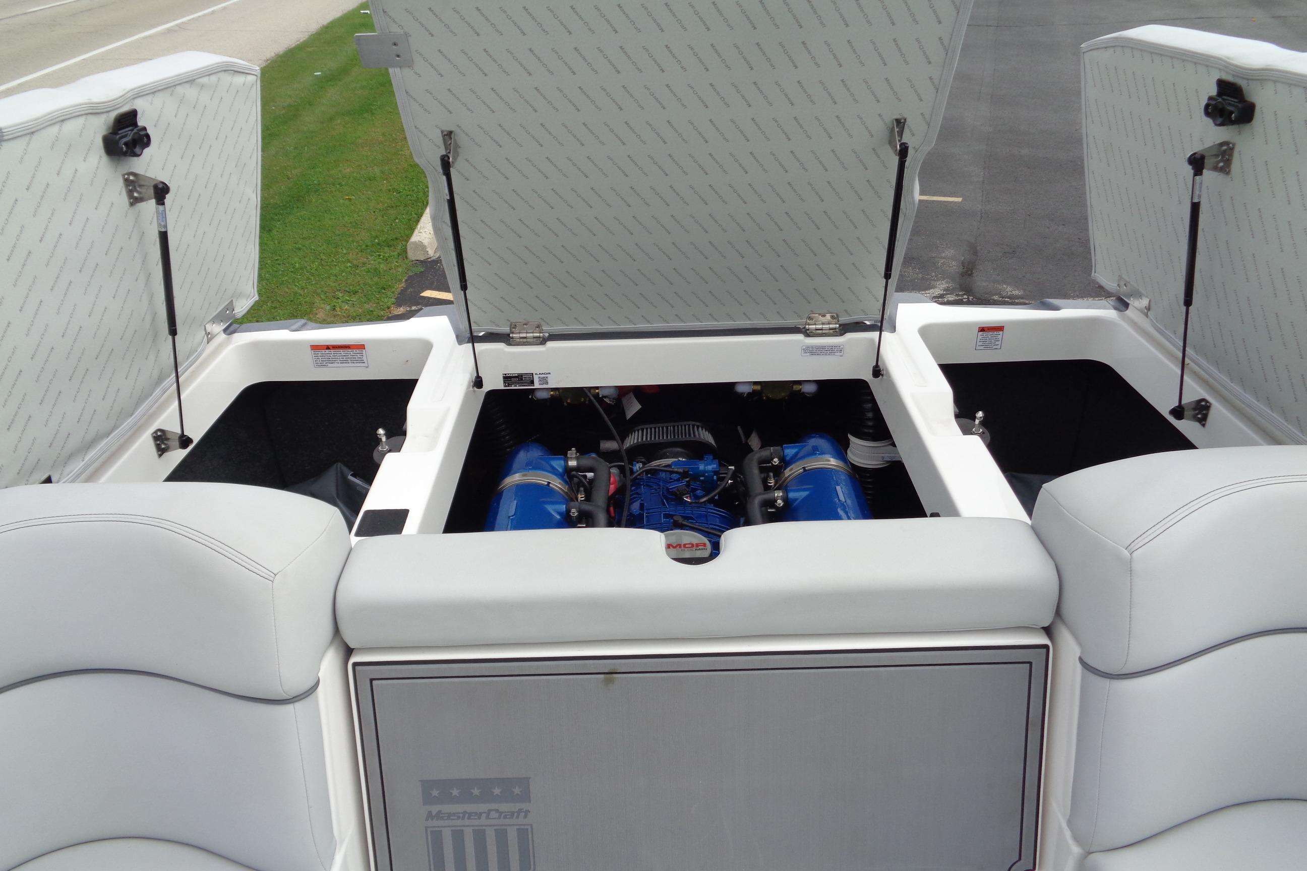 2020 MasterCraft XT23 boat engine compartment with open hatches, showcasing interior details.
