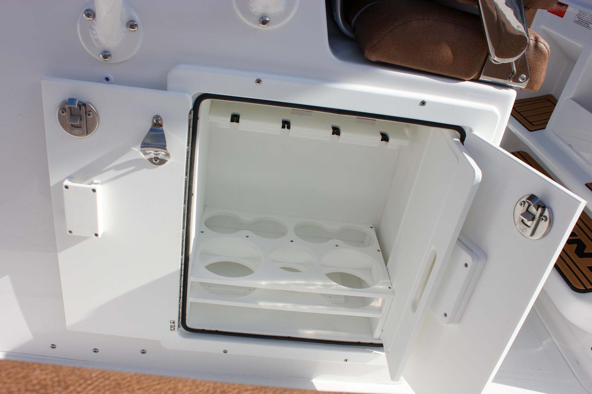 Open storage compartment on 2027 Sea Hunt Ultra 275 SE boat, featuring cup holders.