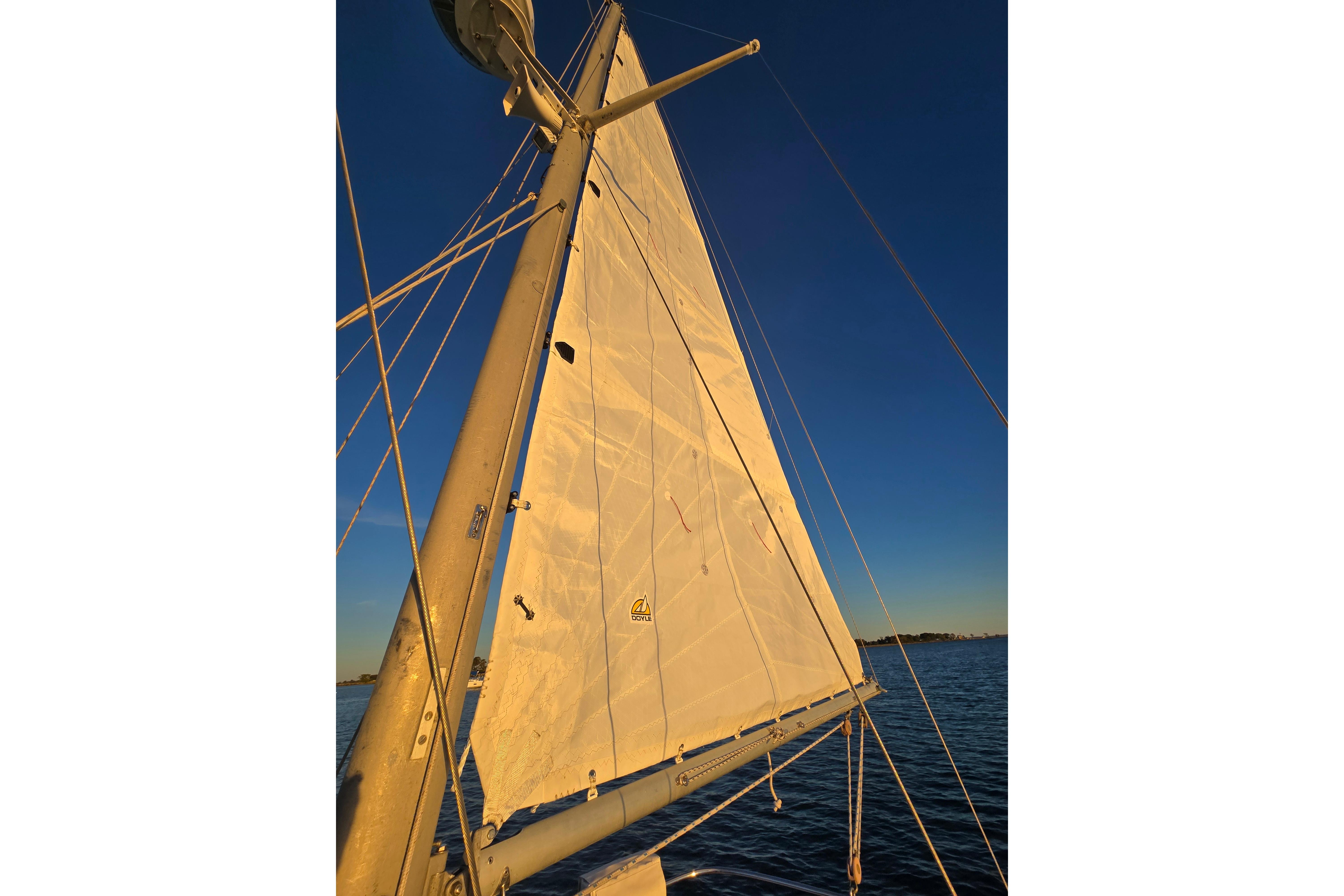 Sail of a 1970 Hinckley Bermuda 40 yacht against a clear blue sky.