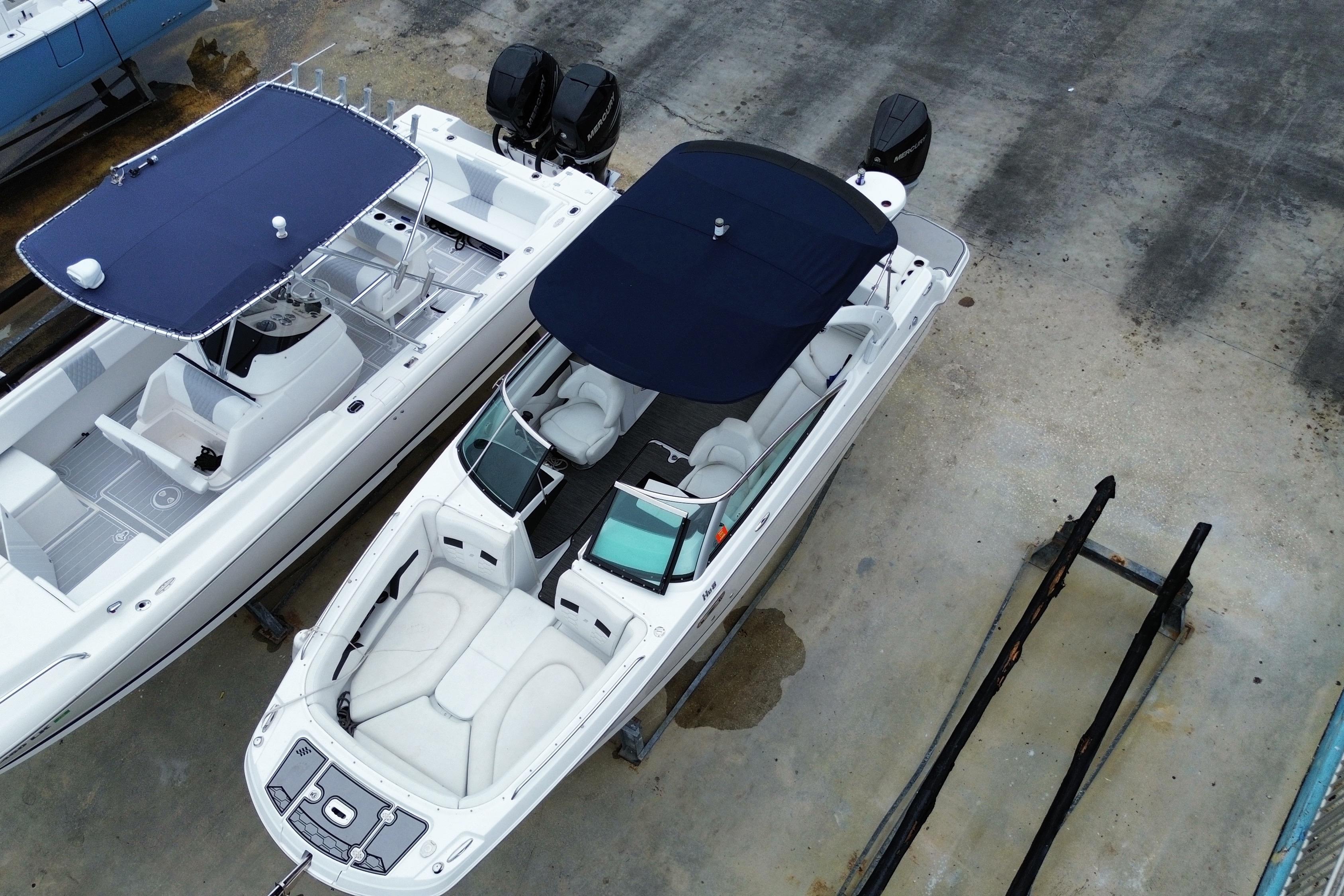 2022 Four Winns HD8 OB boat with blue canopy, docked alongside another vessel.