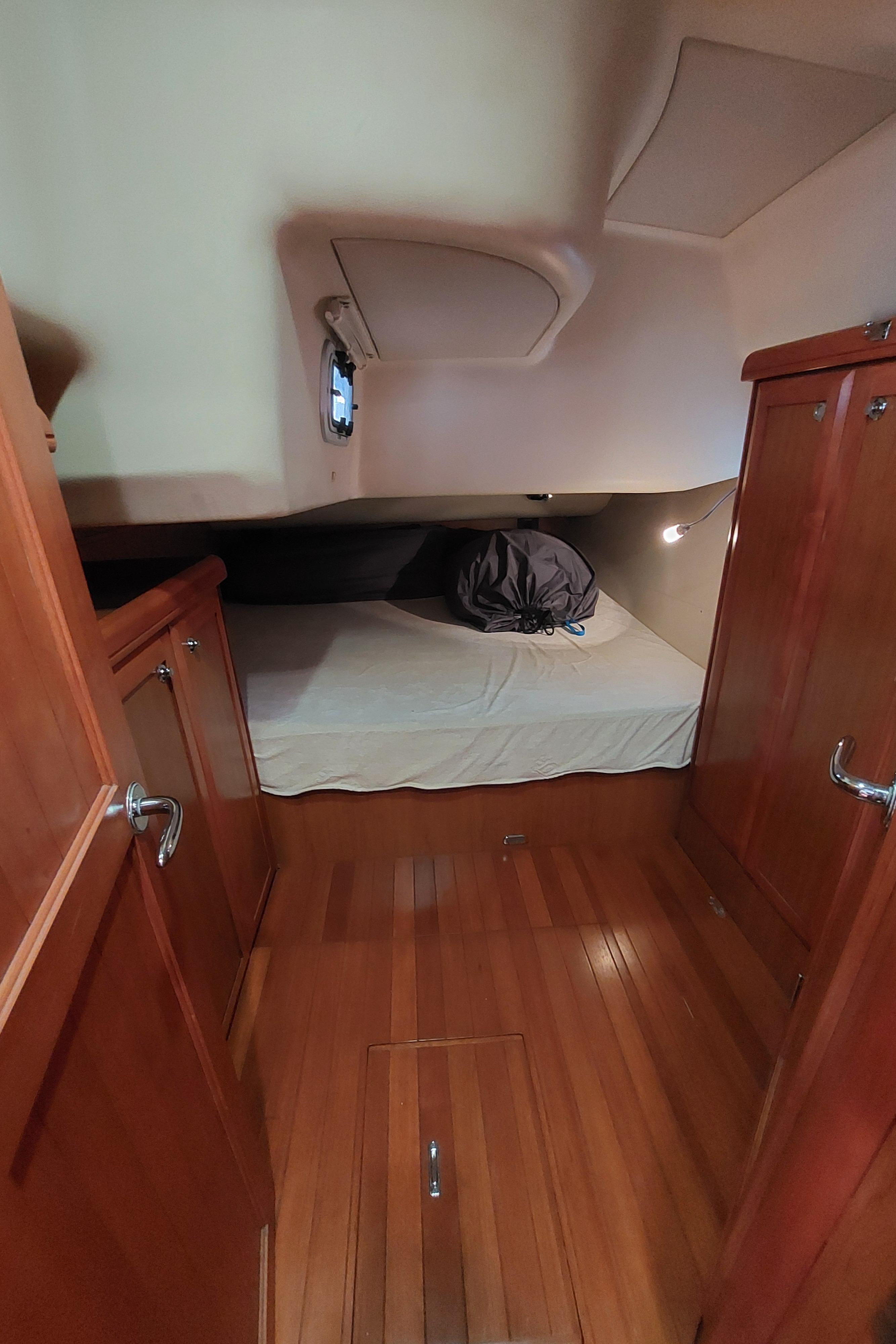 2009 Hunter 49 yacht cabin with wooden interior and cozy bed.