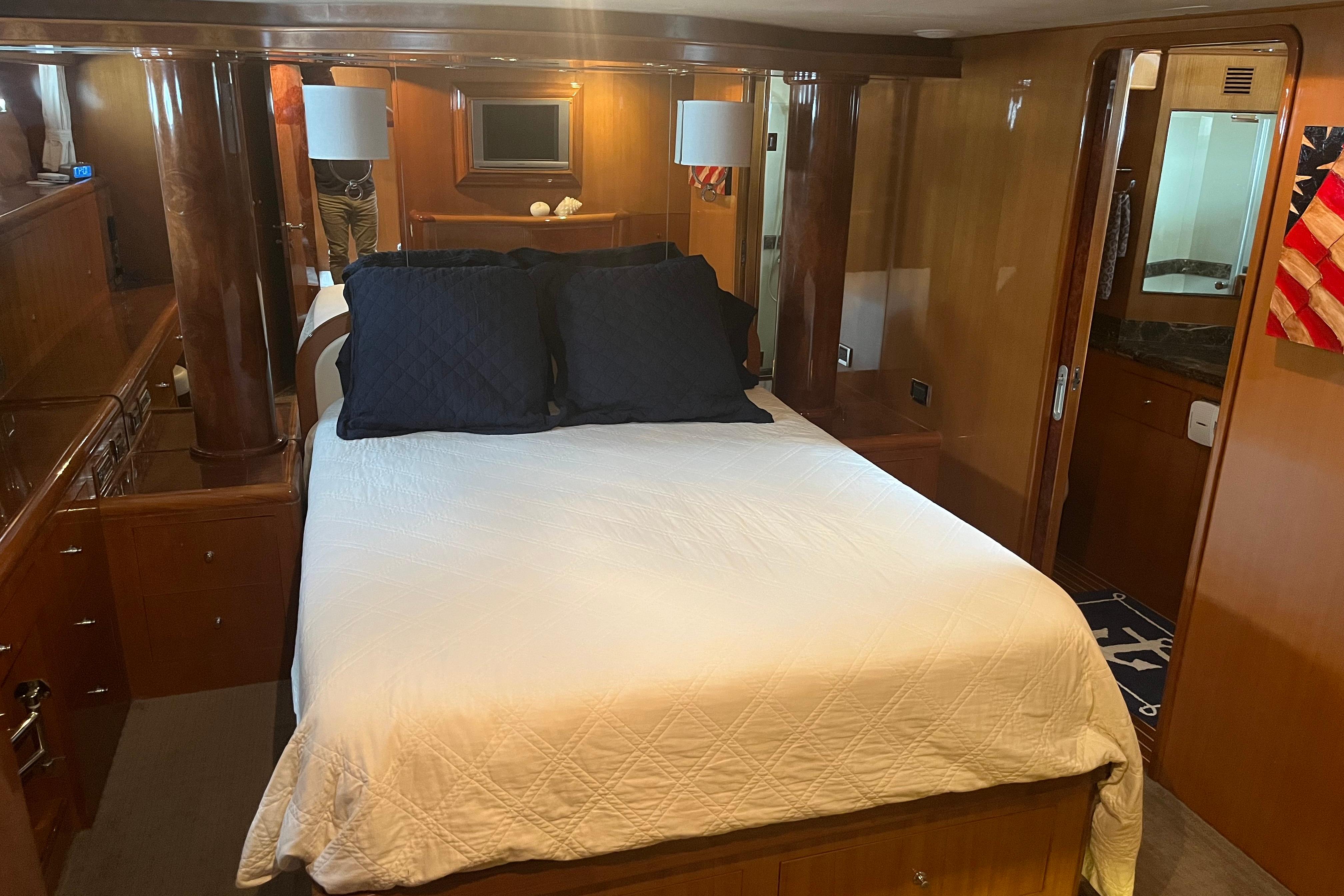 Luxurious bedroom interior of 2004 Ocean Alexander 64 Pilothouse yacht with elegant wood finishes.