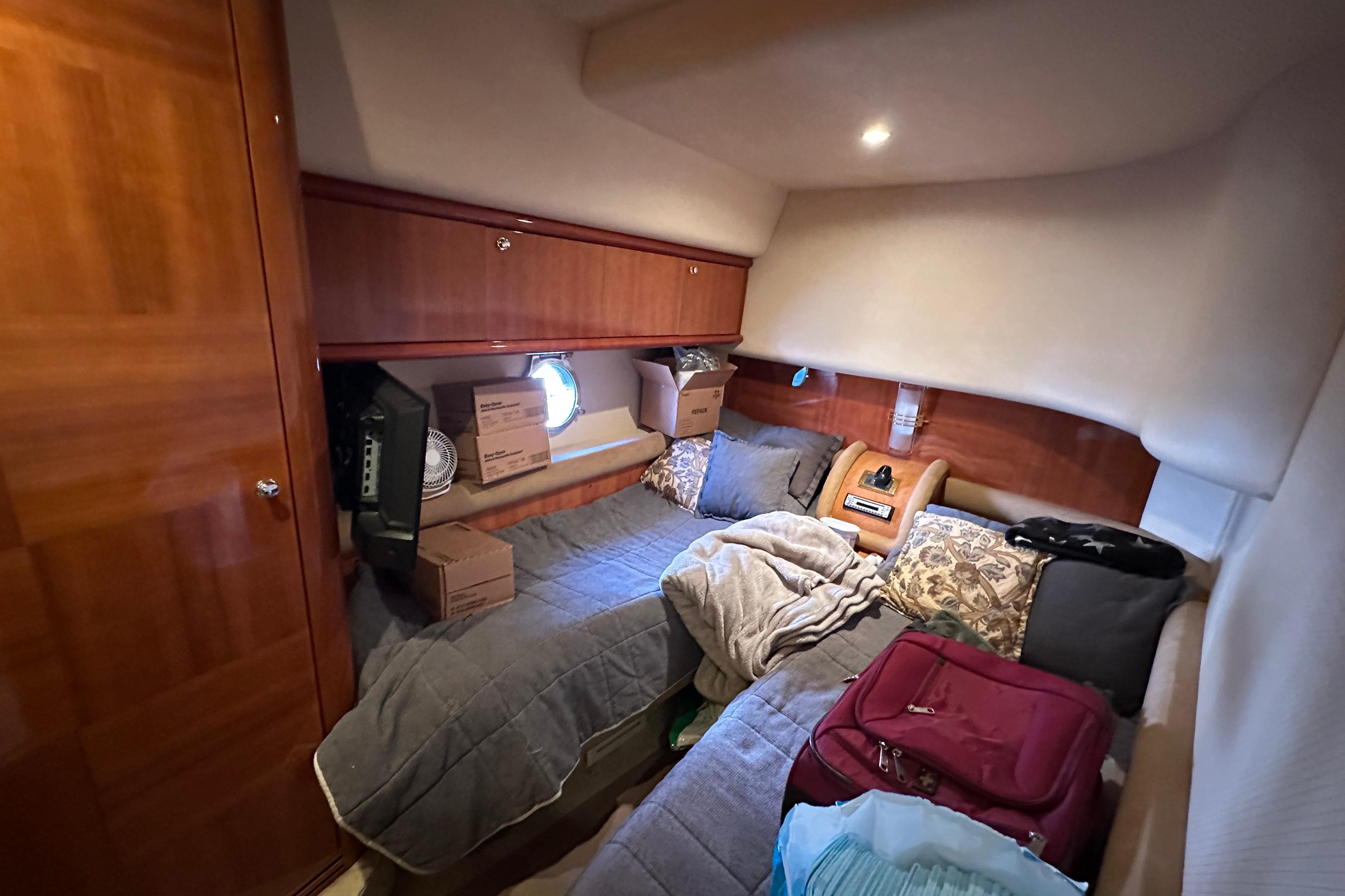 Cozy cabin interior of 2004 Azimut 55E yacht with twin beds and wooden cabinetry.