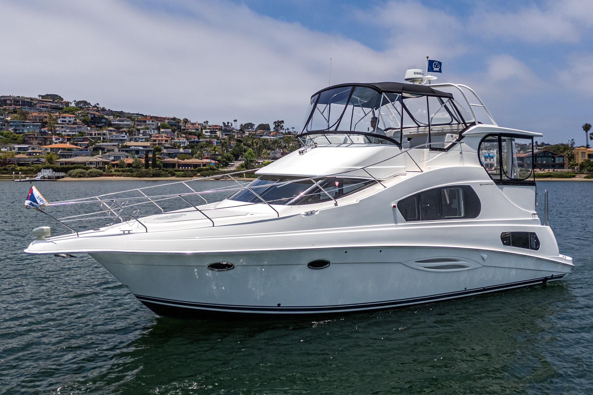 2004 Silverton 39 Motor Yacht on water, coastal background, clear sky.