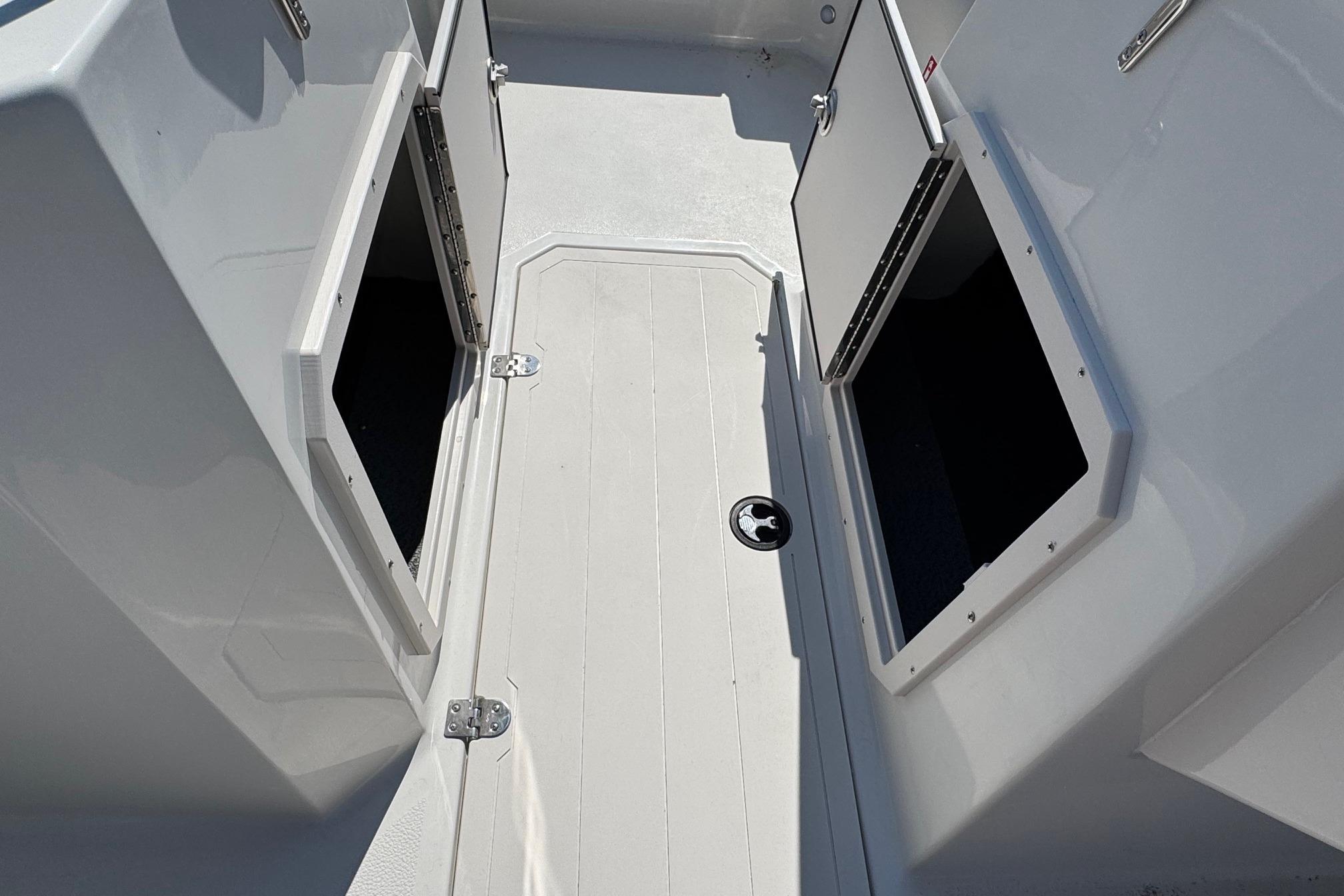 2026 Starcraft SVX 190 OB boat storage compartments, open hatches, white interior.