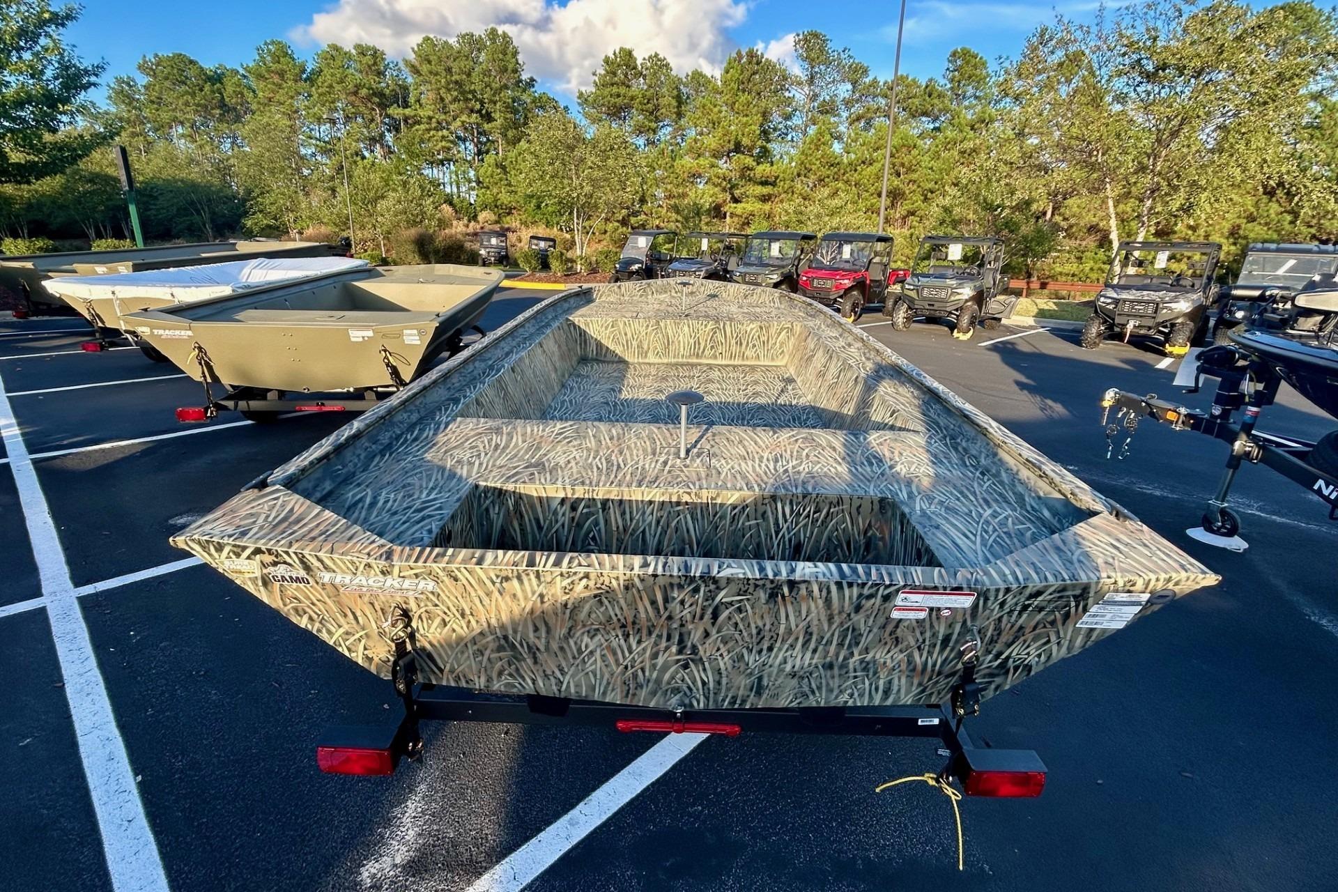2026 Tracker Grizzly 1860 Utility boat with camouflage design in outdoor showroom.