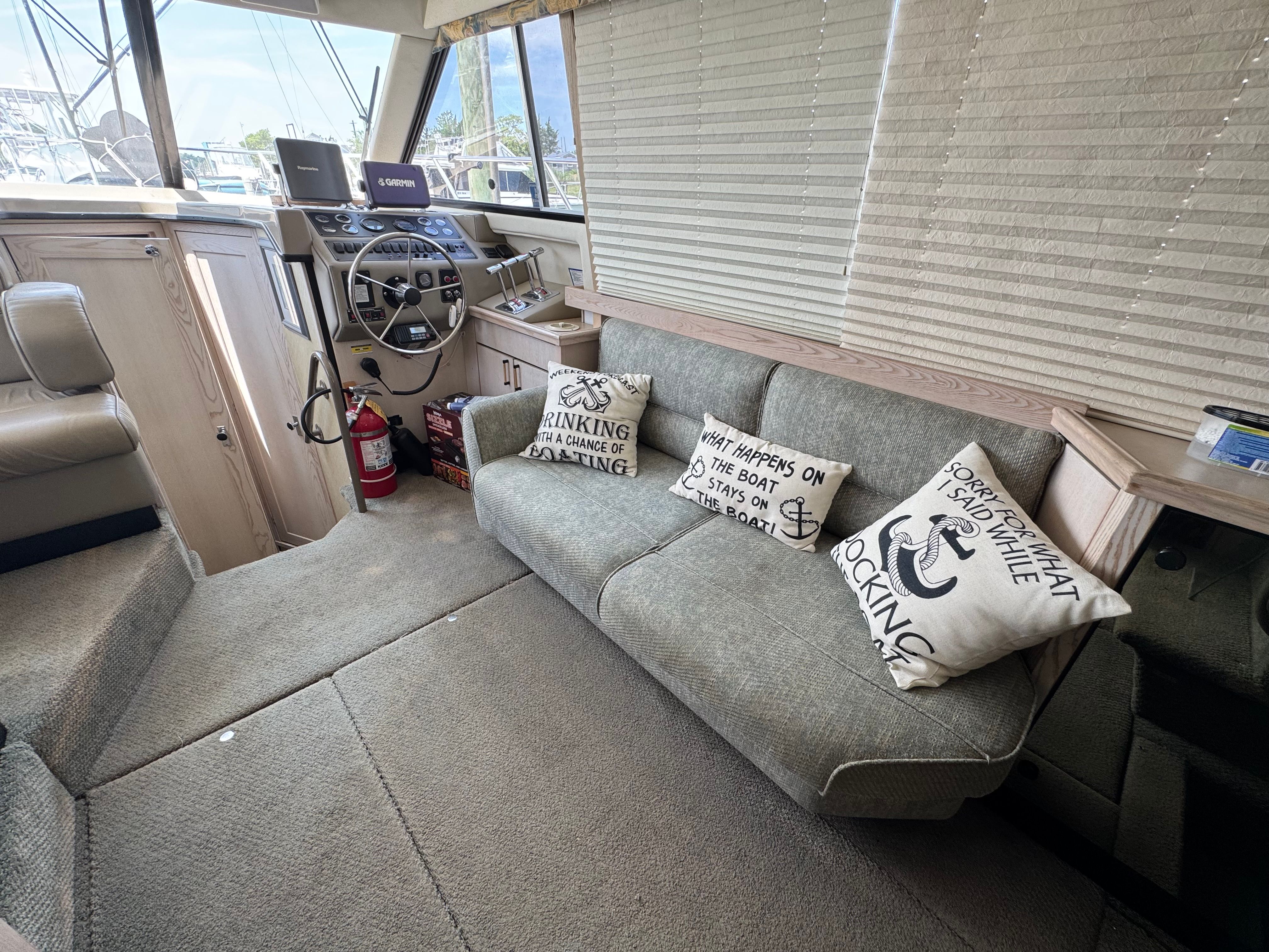 Interior of a Bayliner 3587 yacht with cozy sofa and cushions.